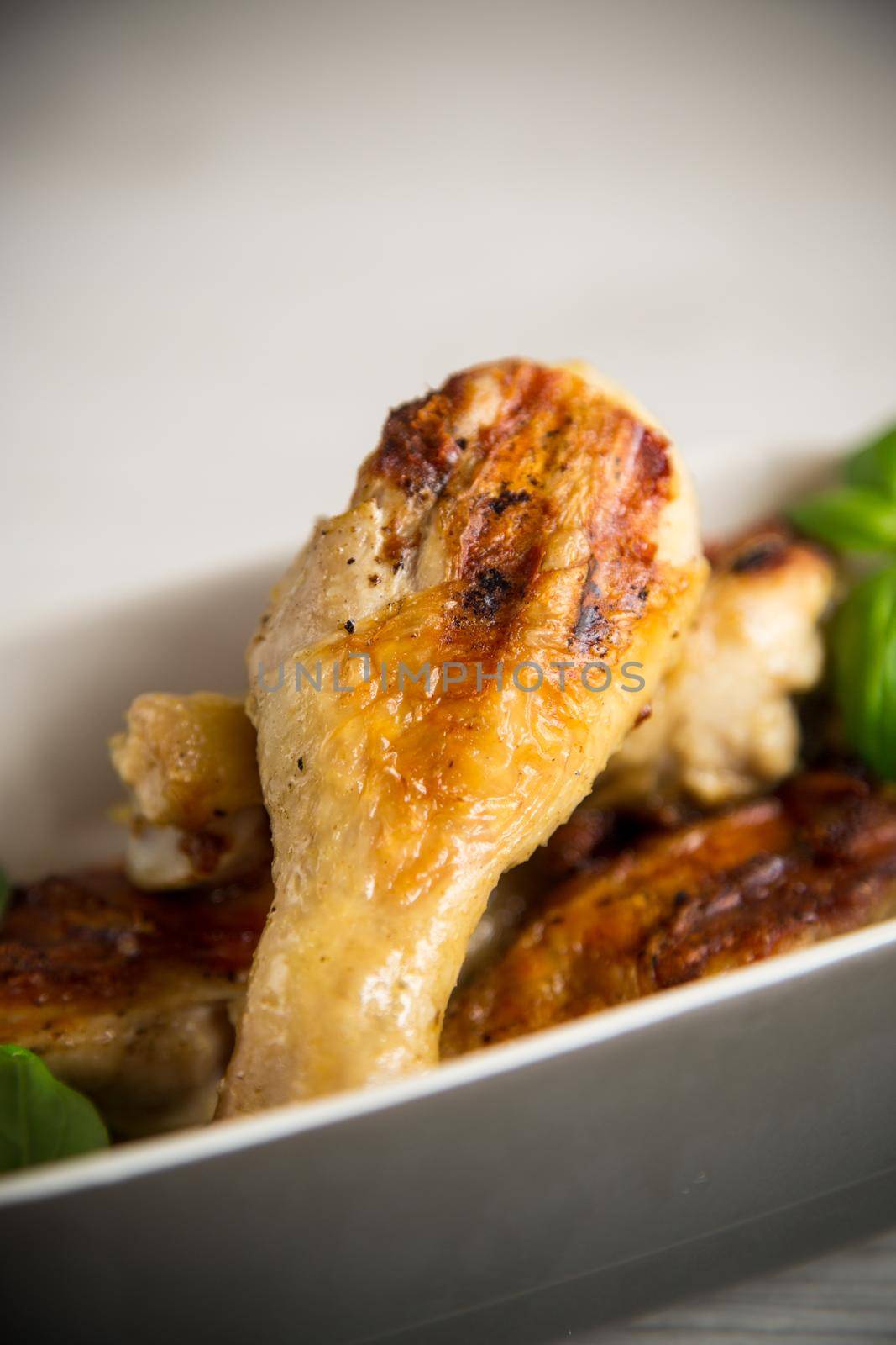 grilled chicken legs fried with spices and herbs in a ceramic bowl