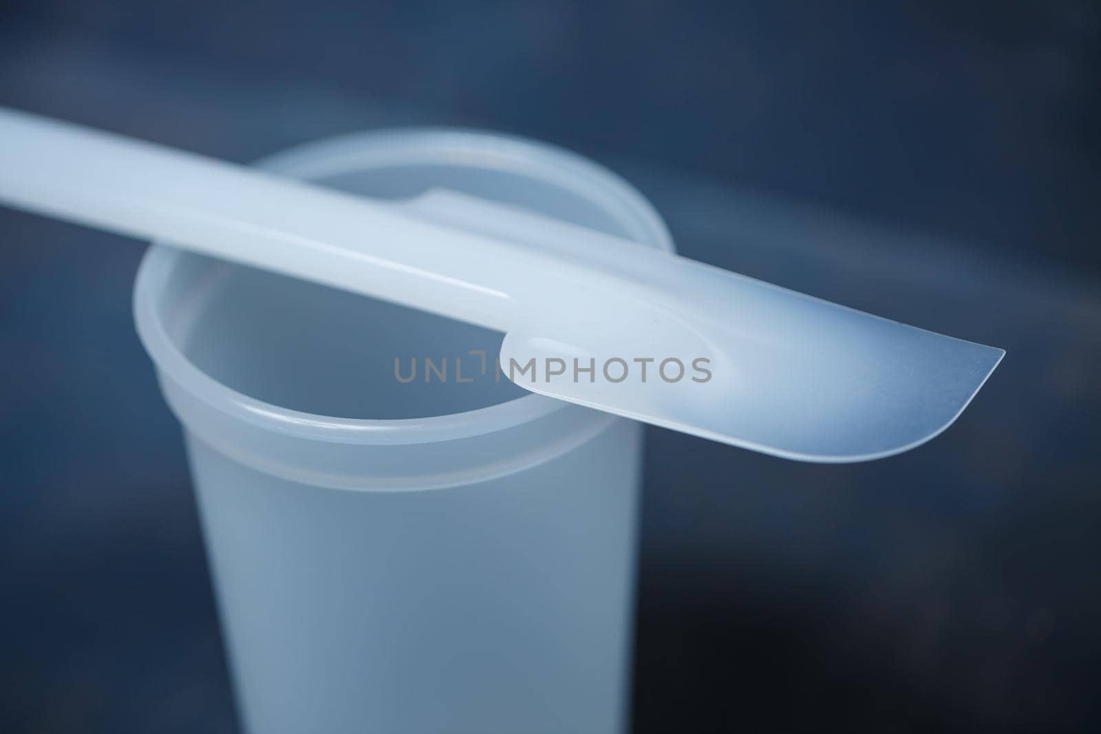 Plastic glass for mixing cream on a gray background