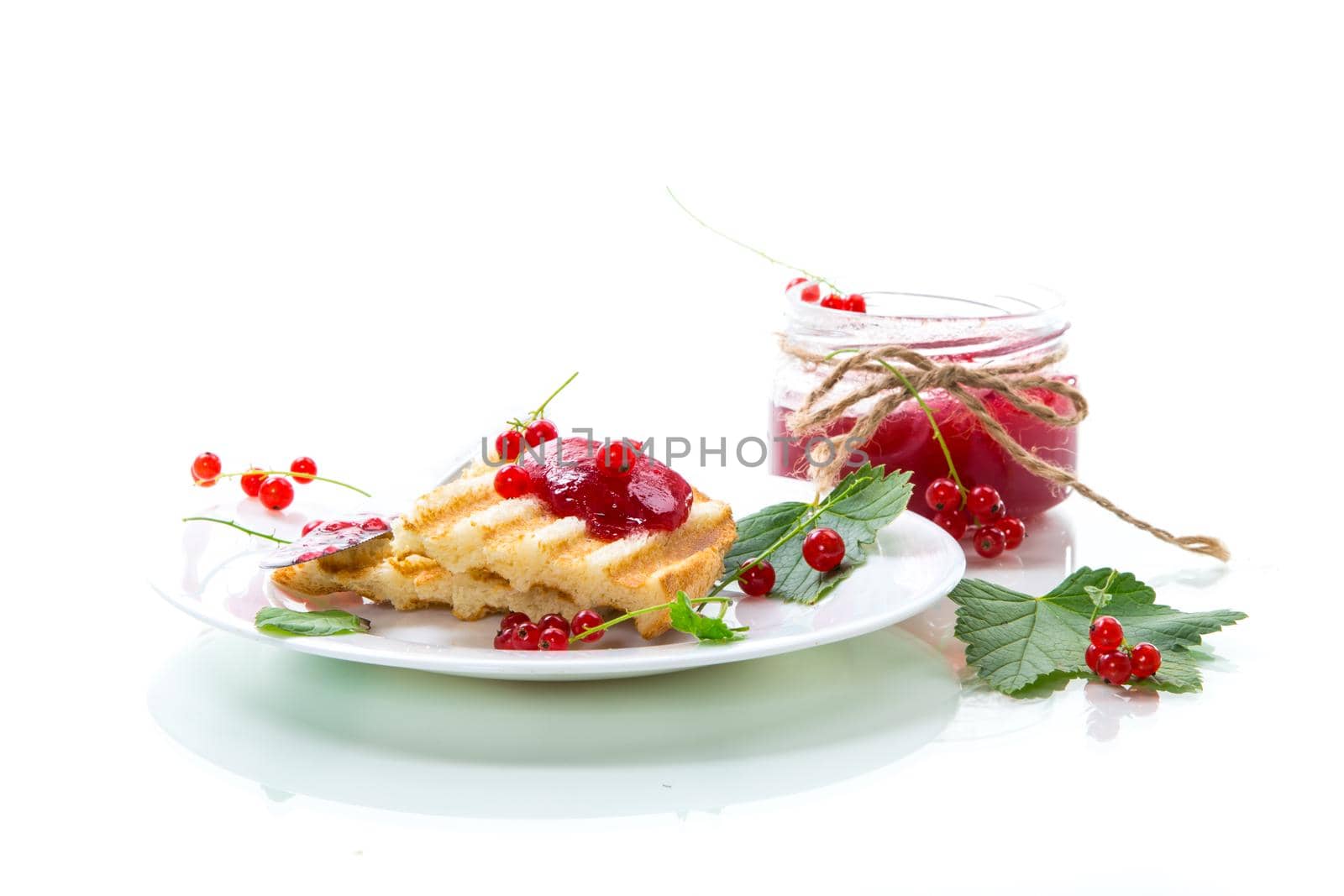 fried bread croutons for breakfast with redcurrant jam in a plate with berries isolated on white background
