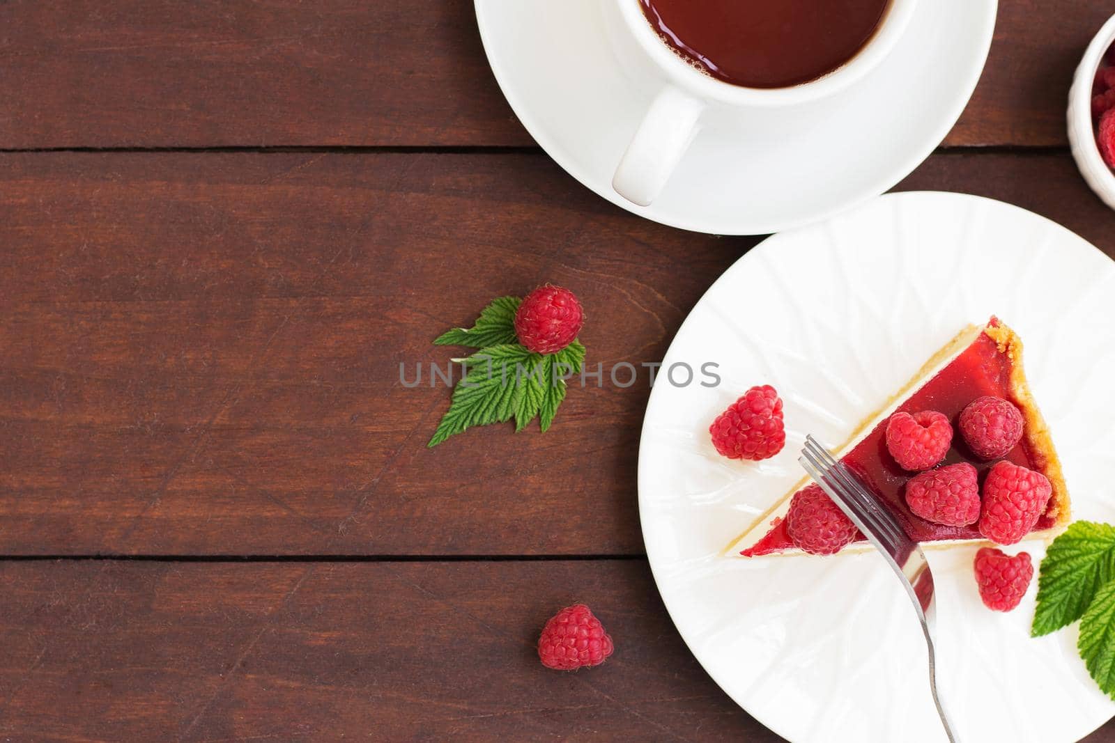 Raspberry pie (cheesecake) made from fresh raspberries with tea on a wooden background. Copy space by lara29