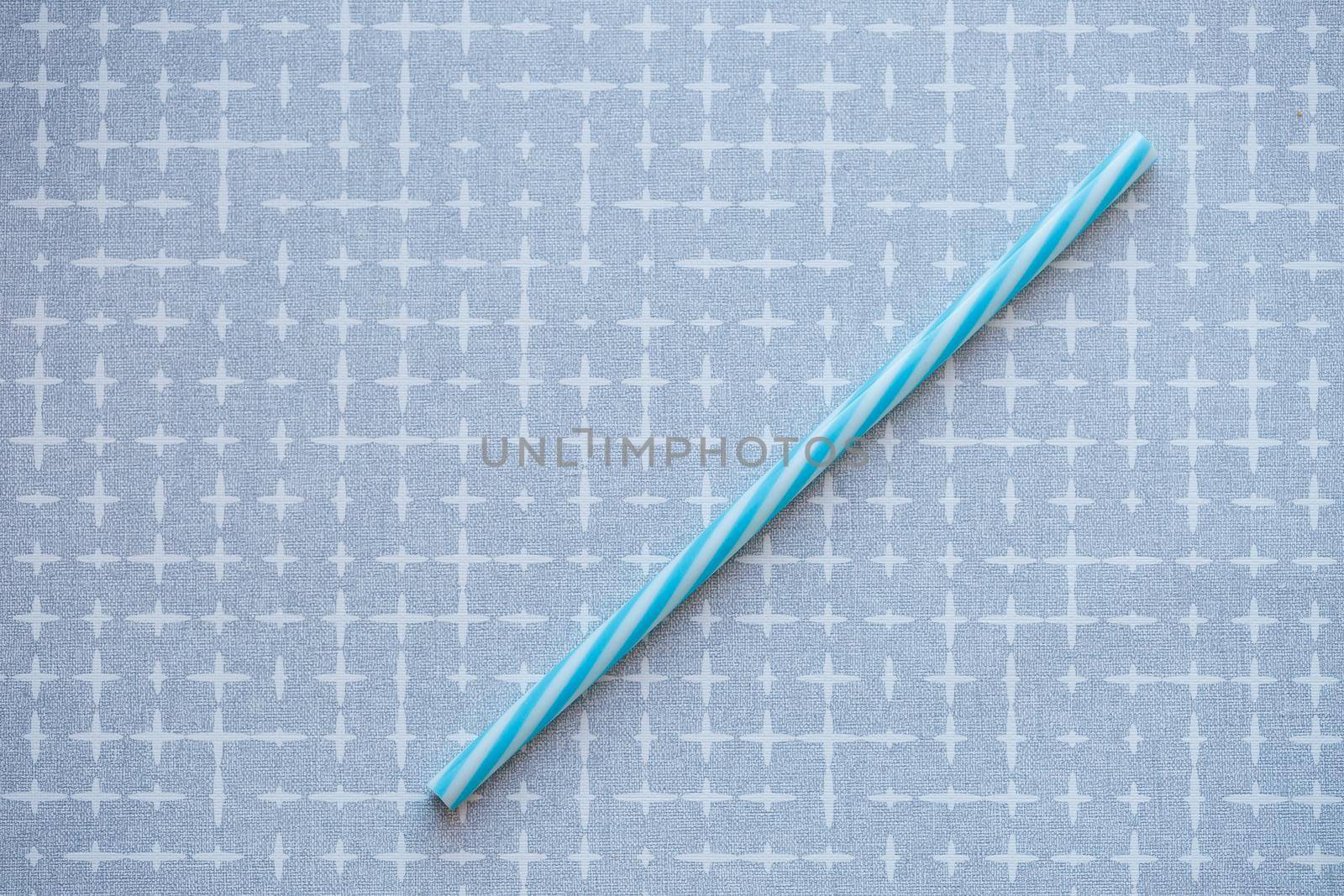 Plastic reusable straw for cocktails on a gray background