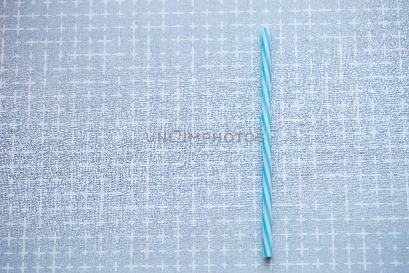 Plastic reusable straw for cocktails on a gray background