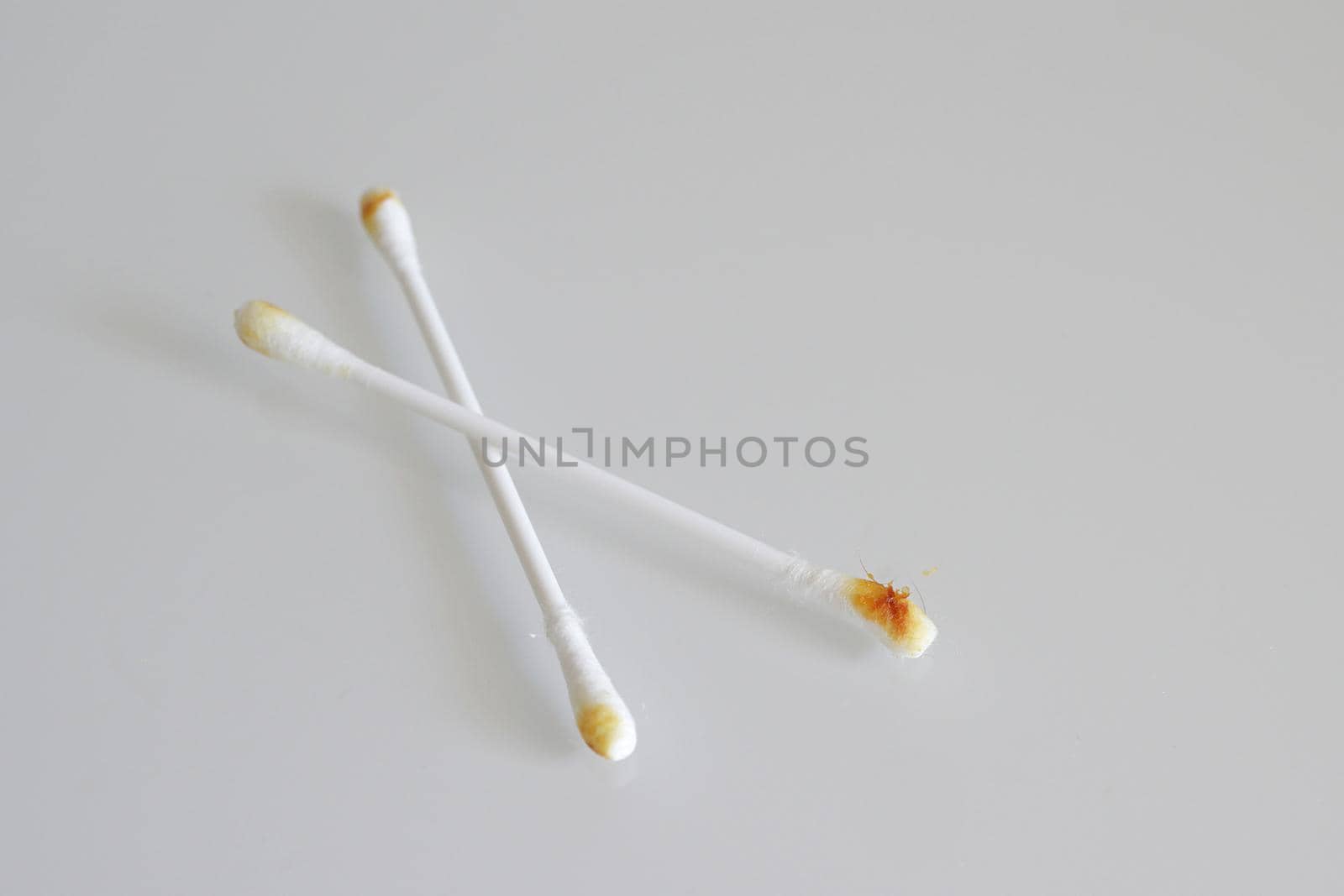 Cotton swab used for cleaning ear with sulfur on white background by Proxima13