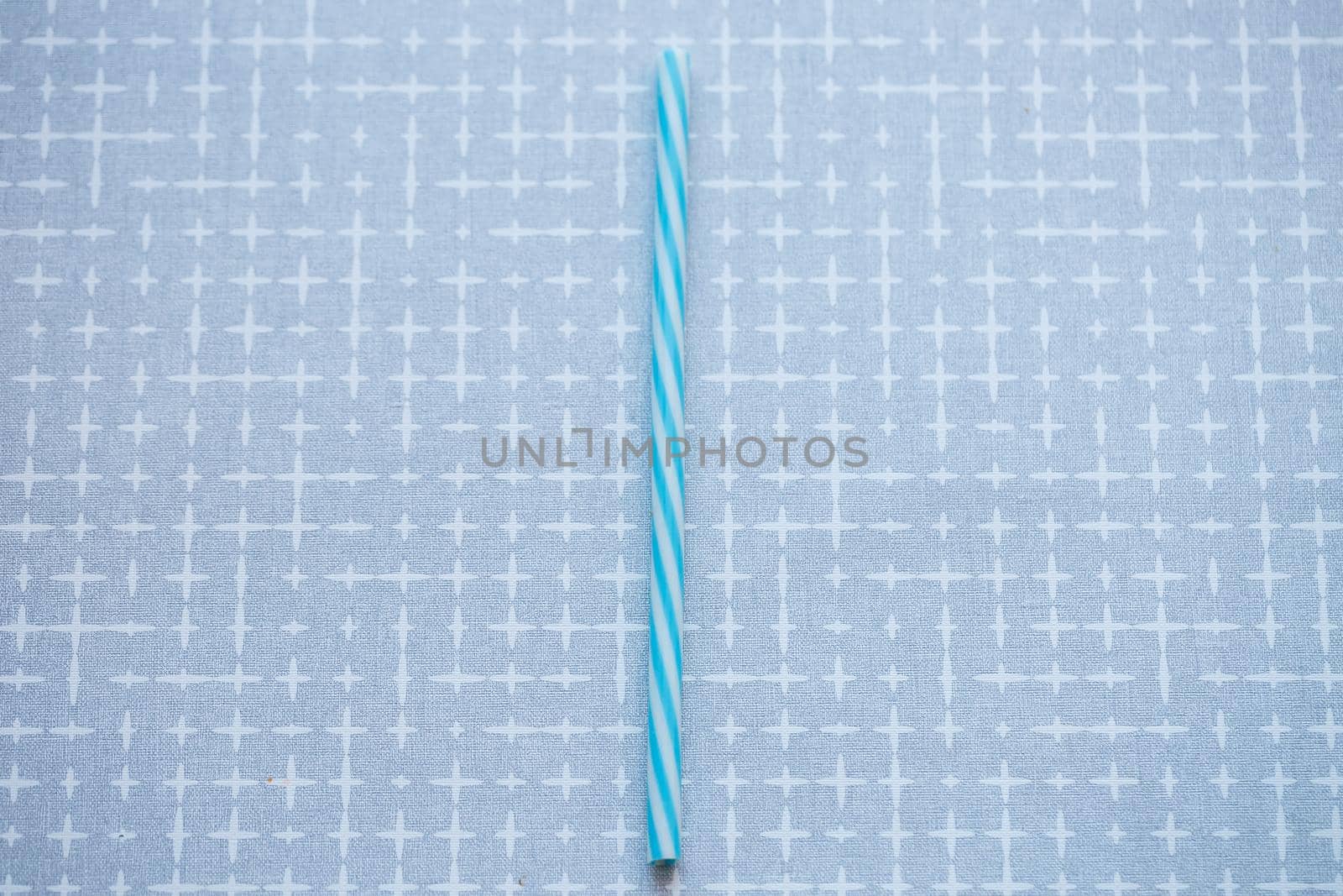 Plastic reusable straw for cocktails on a gray background