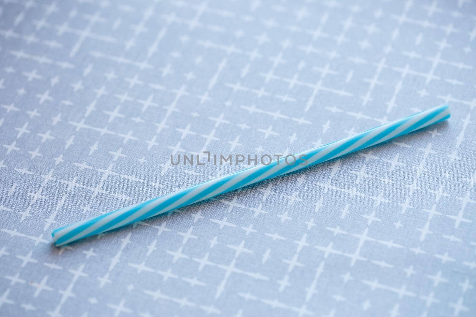 Plastic reusable straw for cocktails on a gray background