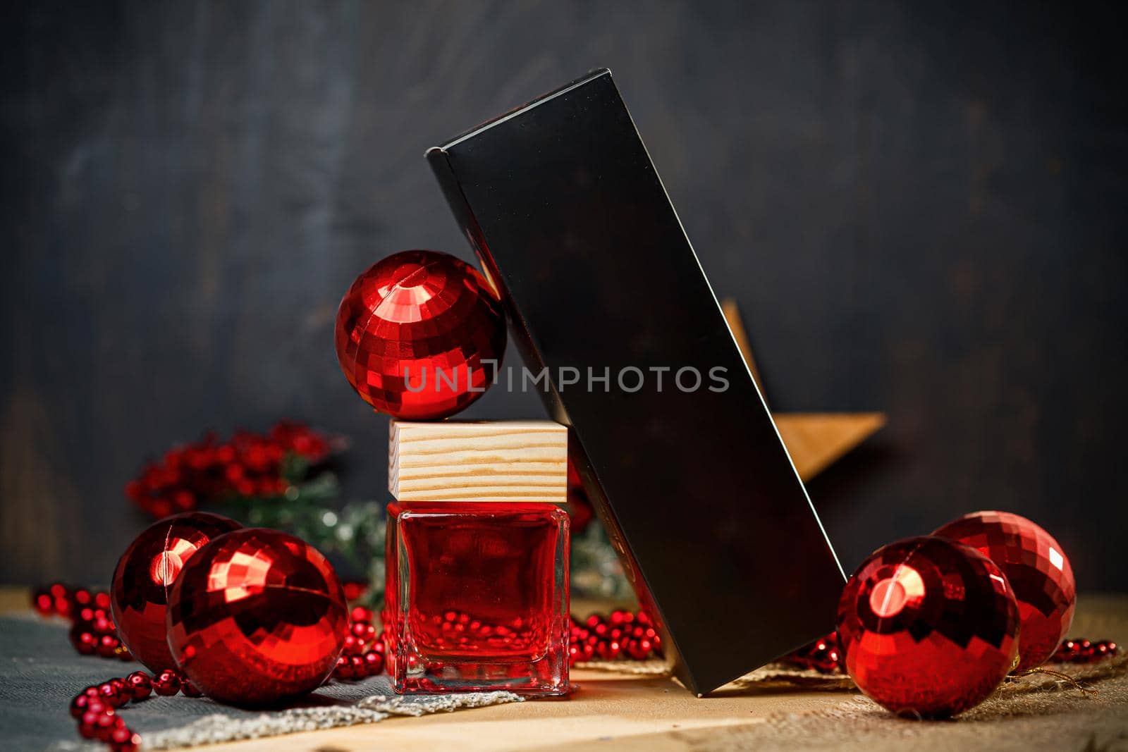 Perfume bottle New Year's gift. Stylish New Year decor perfume bottle is under the tree. Fashionable perfumes in New Year's locations. Perfumes for women
