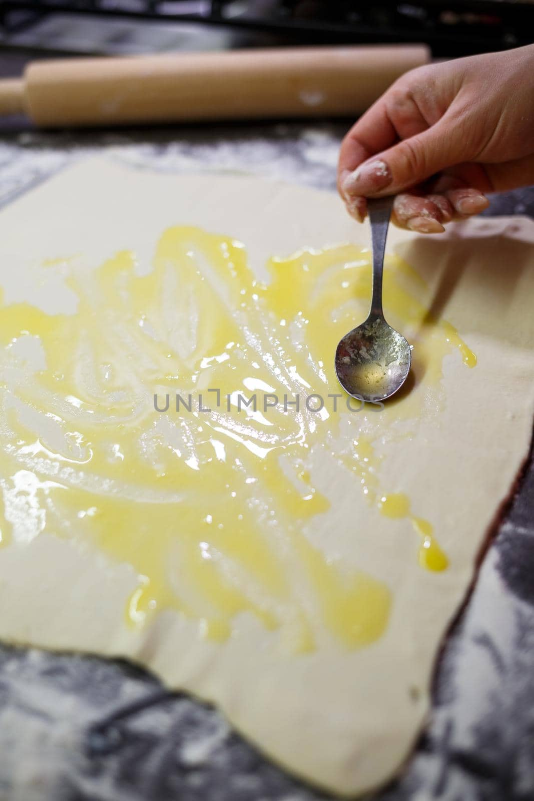Baking domestic rolls with cheese. Putting cheese on dough for rolls