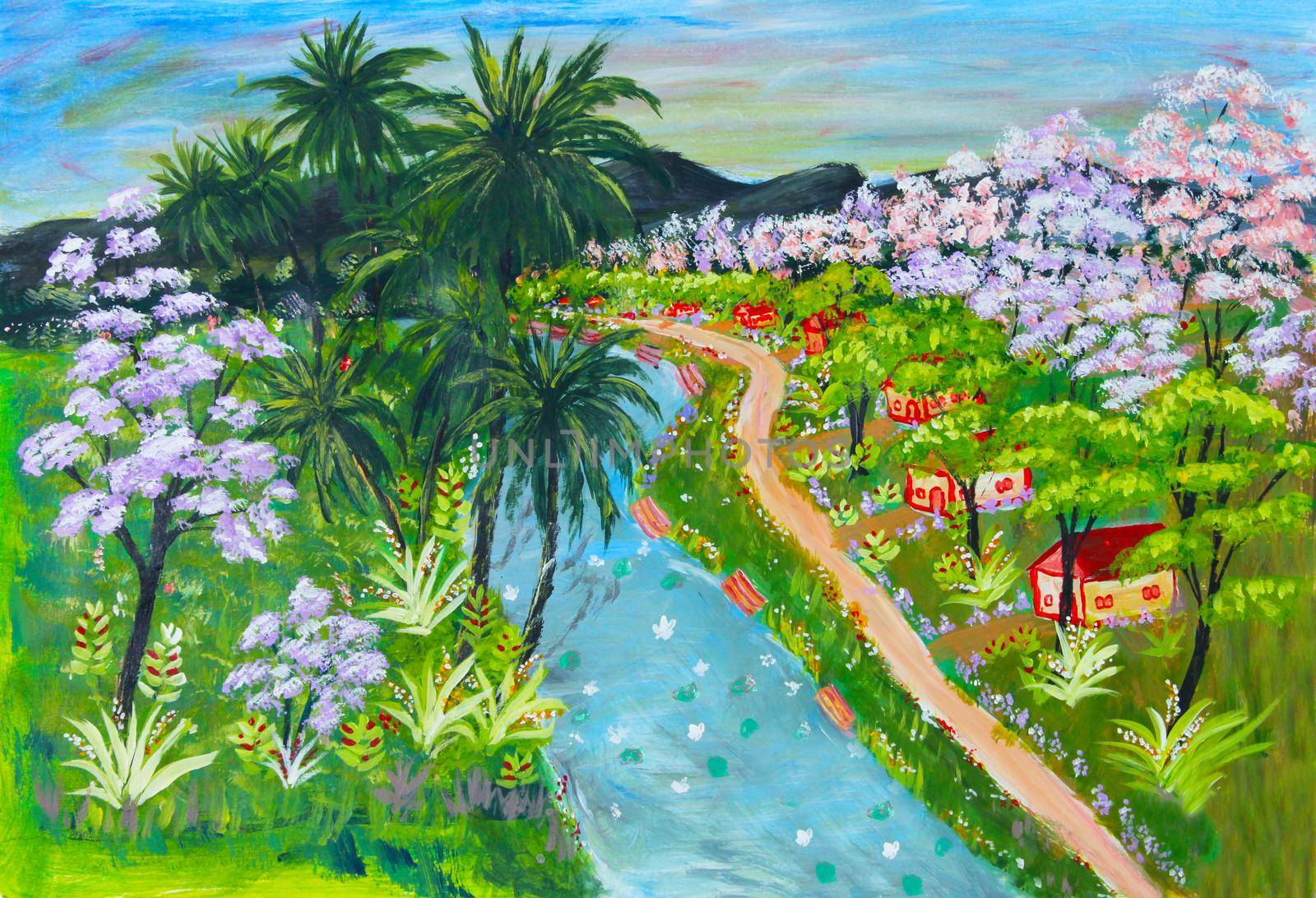 Small rural village huts and homes along a flowing river in a tropical country with coconut trees and flowering trees in full bloom