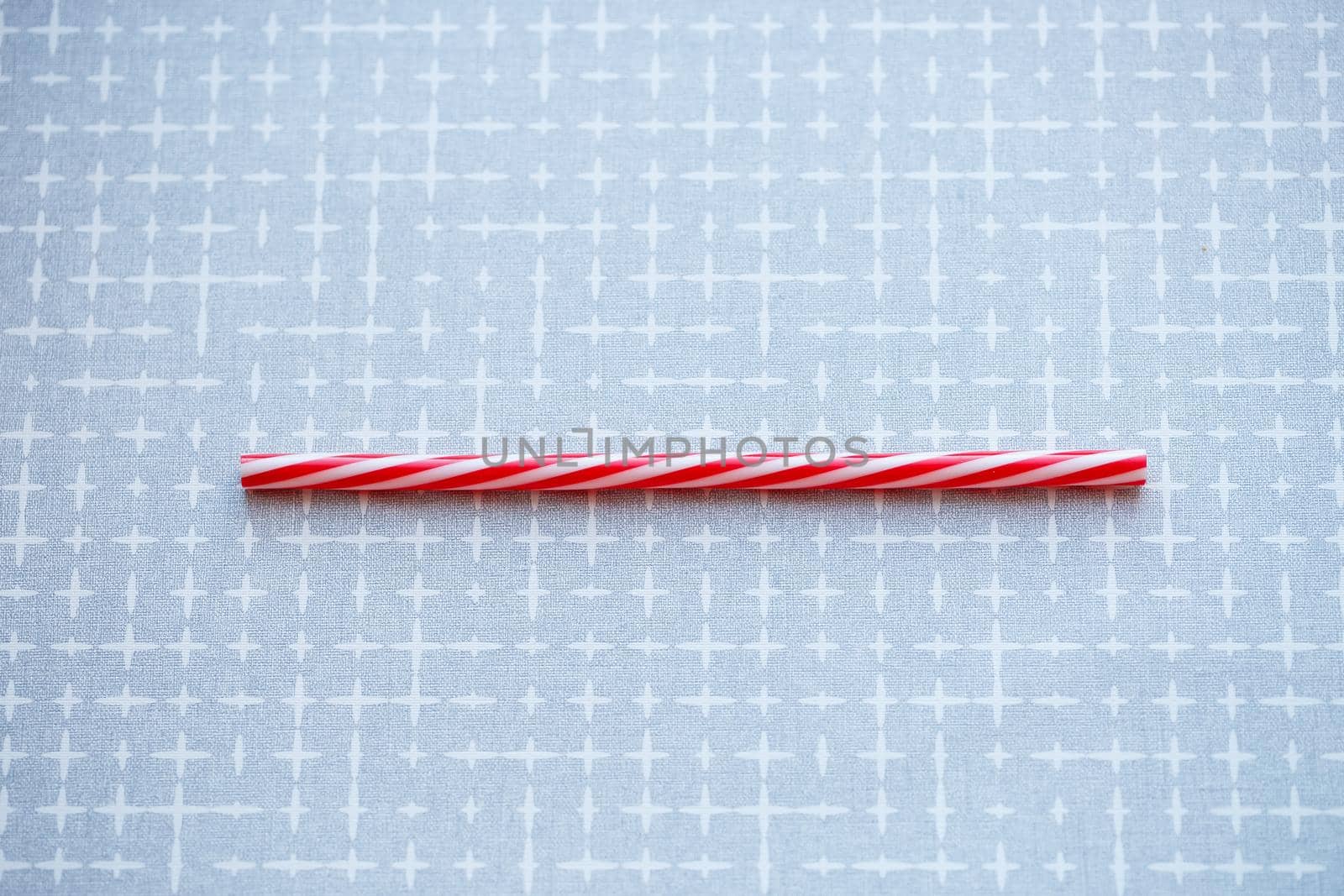 Plastic reusable straw for cocktails on a gray background