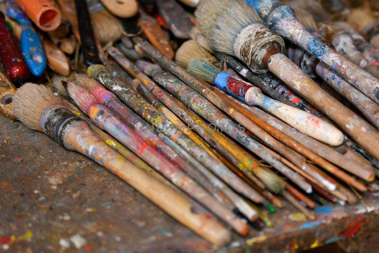 Many used dirty brushes of the artist in the workshop