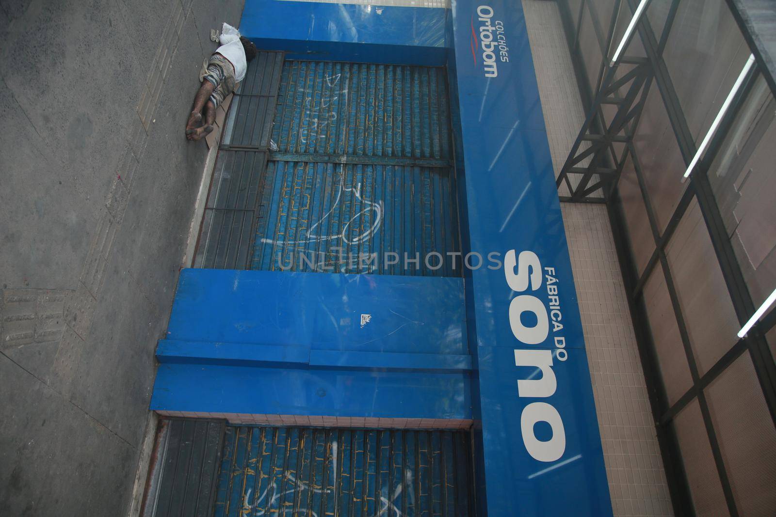 salvador, bahia, brazil - august 6, 2022: homeless man sleeping in front of a collection store in the city of Salvador.
