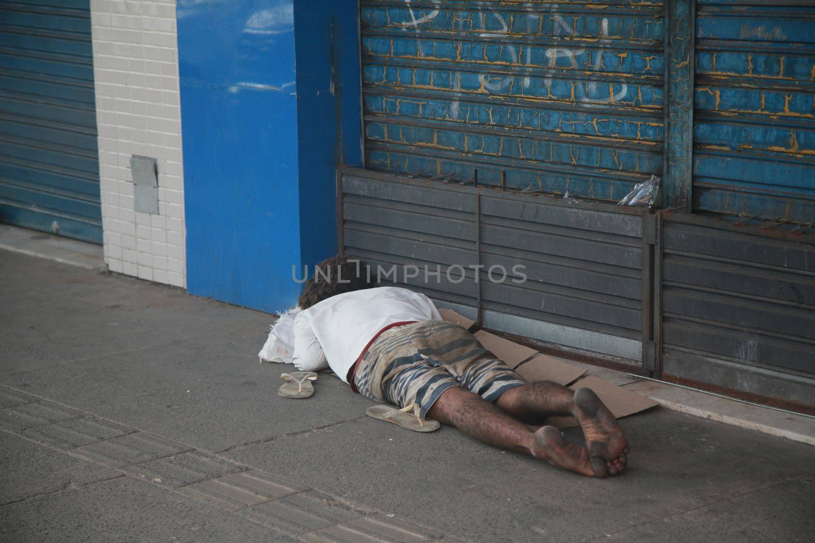 salvador, bahia, brazil - august 6, 2022: homeless man sleeping in front of a collection store in the city of Salvador.
