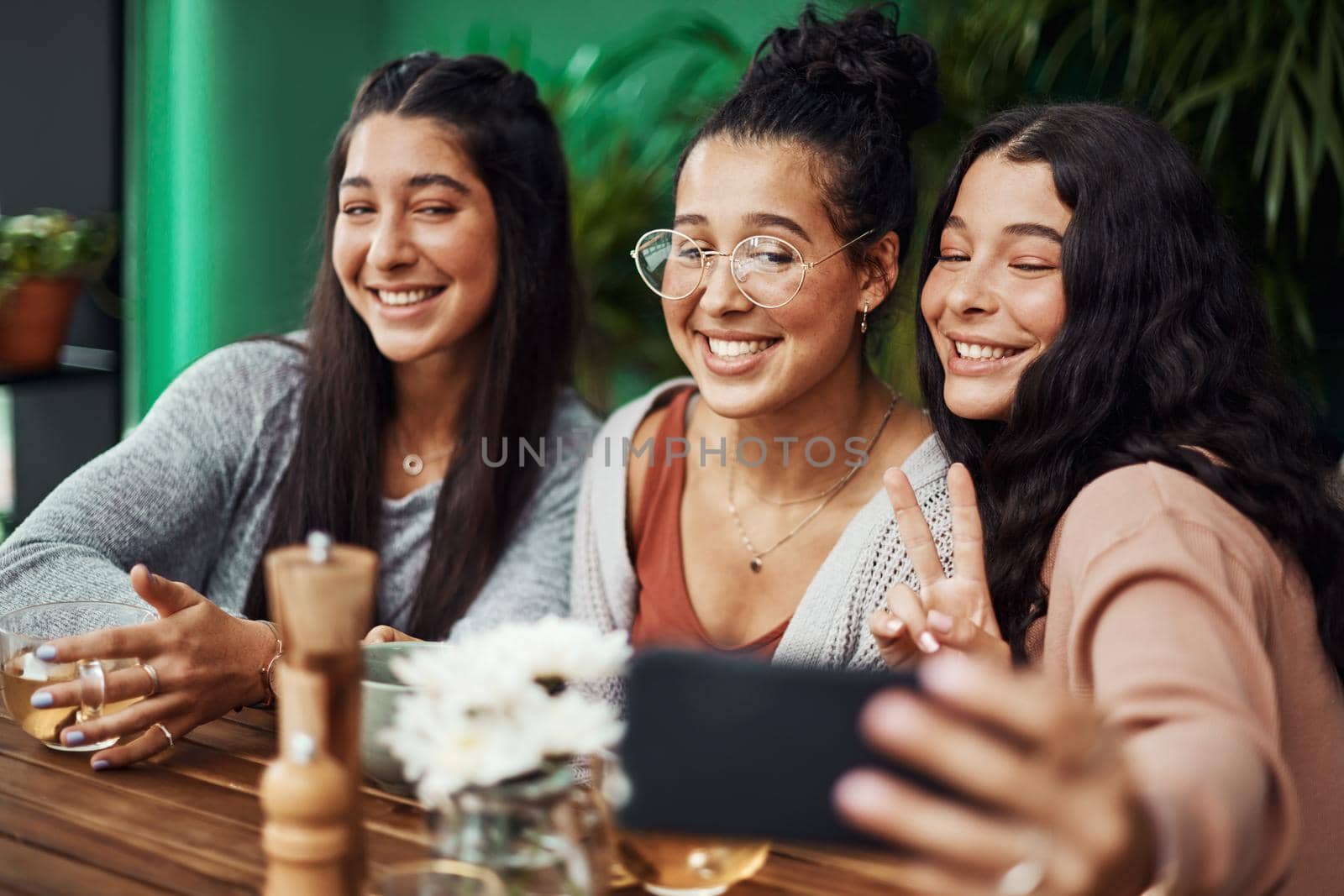 Sister time is selfie time. young sisters taking selfies together at a cafe