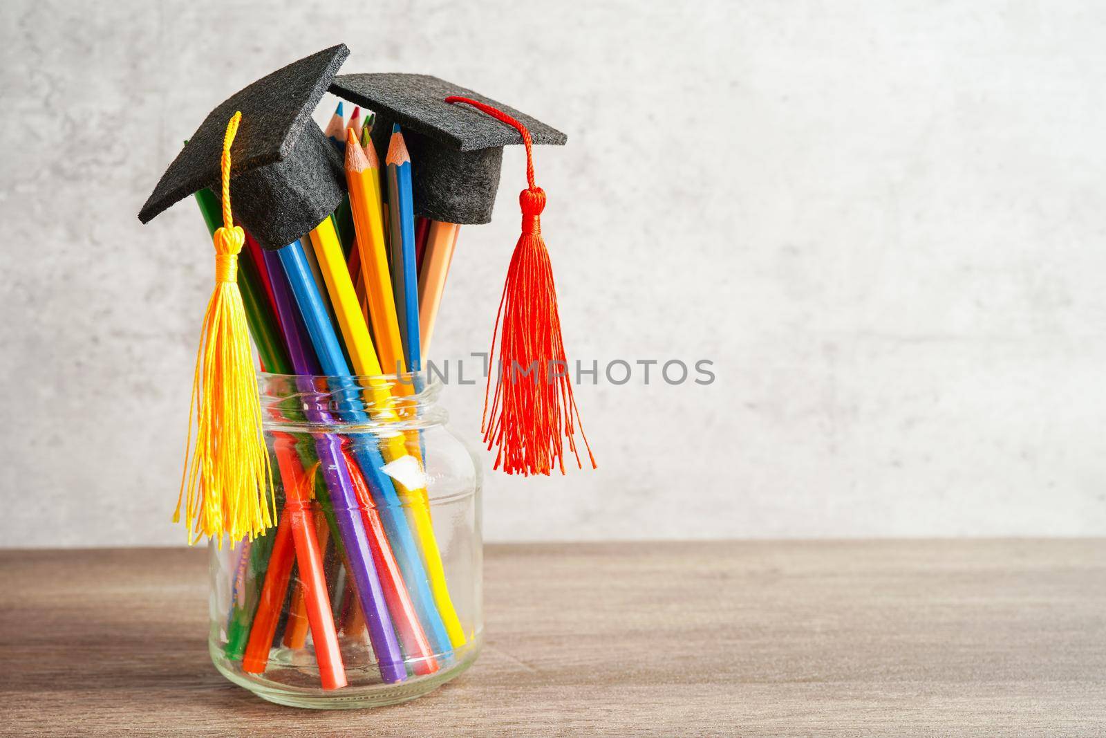 Colorful pencils in glass jar with copy space, learning university education concept.