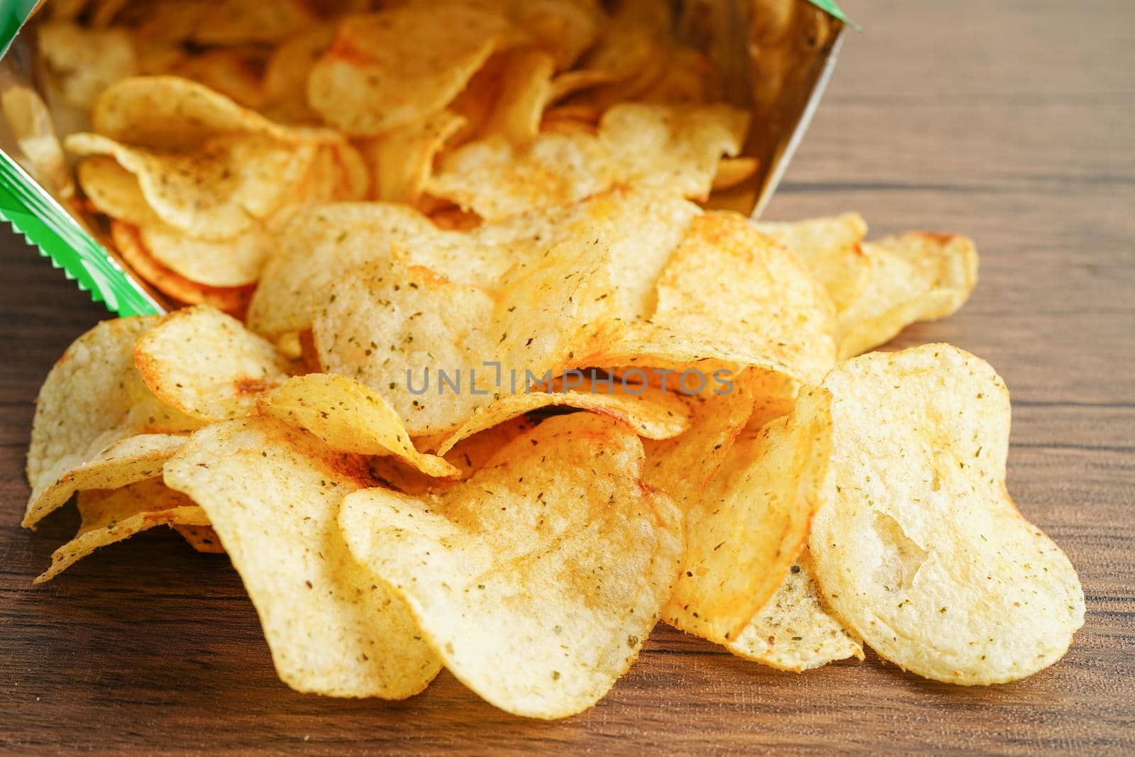 Potato chips in open bag, delicious BBQ seasoning spicy for crips, thin slice deep fried snack fast food in open bag.