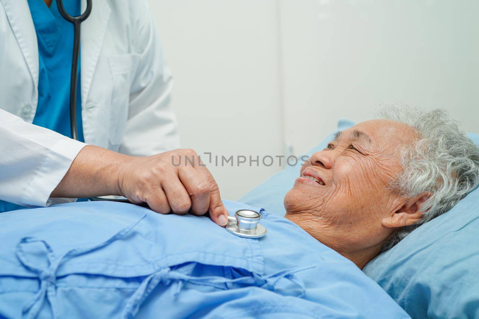 Doctor taking care, help and encourage Asian elder senior woman patient in clinic hospital.