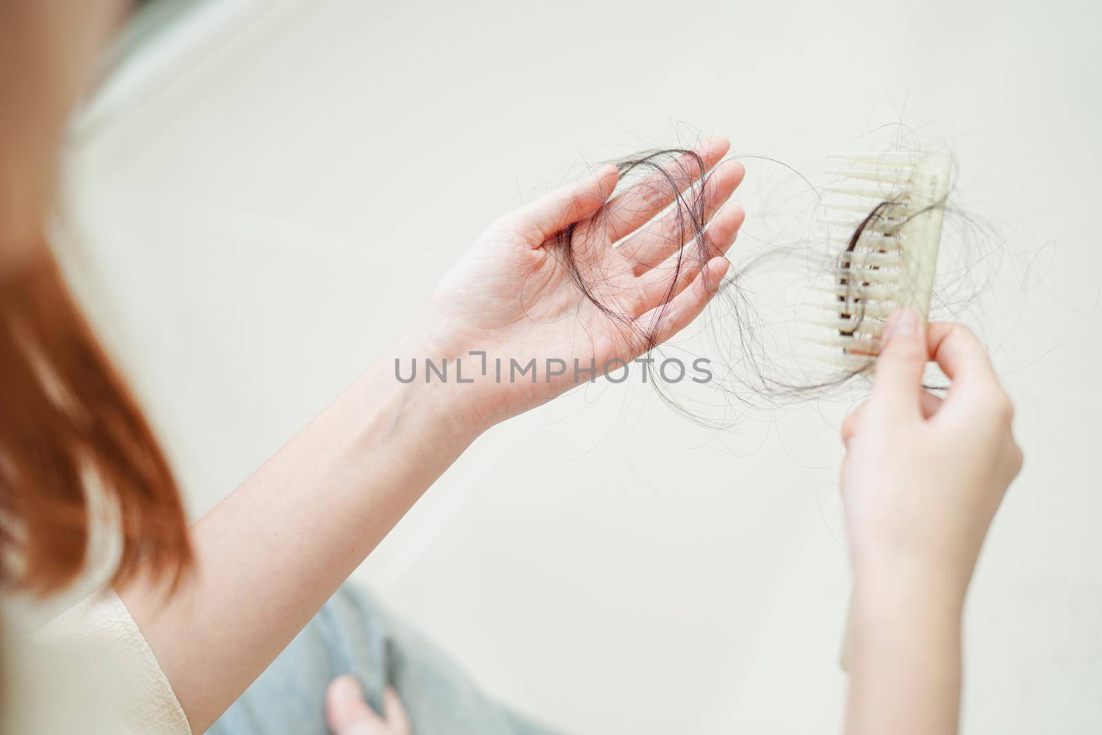 Asian woman have problem with long hair loss attach in her hand.