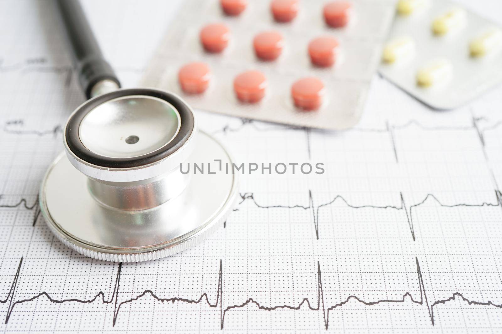 Stethoscope on electrocardiogram (ECG) with drug, heart wave, heart attack, cardiogram report.