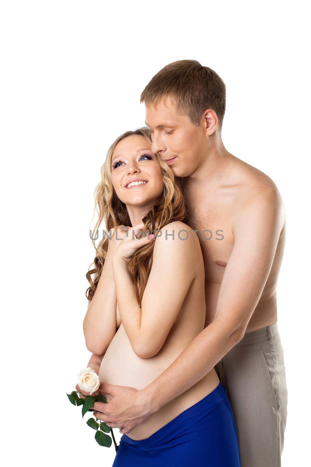 Young man take a belly of pregnant wife with white rose