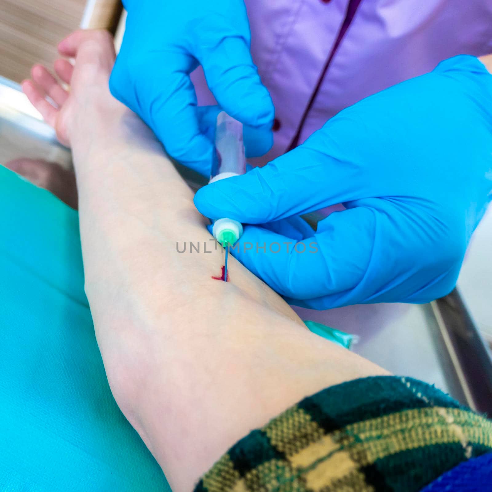 Close up nurse pricking needle syringe in the arm patient drawing blood sample for blood test