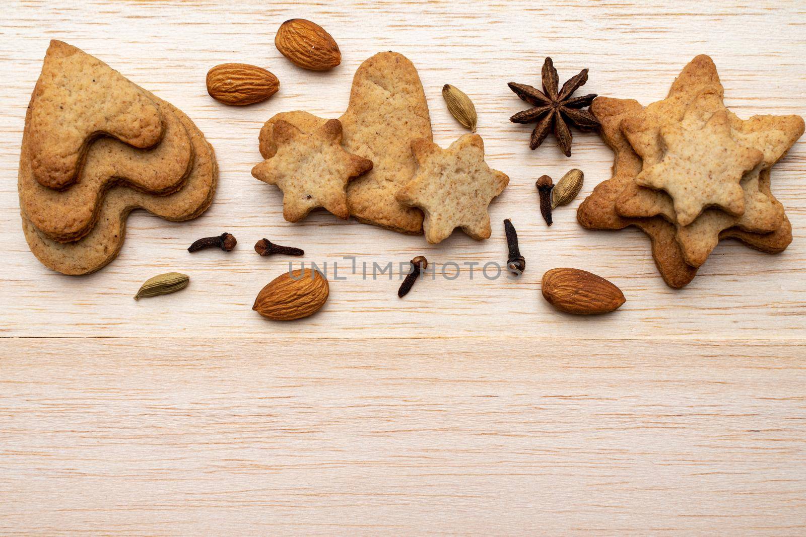 Christmas holiday background with homemade cookies on a wooden table. Cloves, star anise, almonds. Copy the location for the text