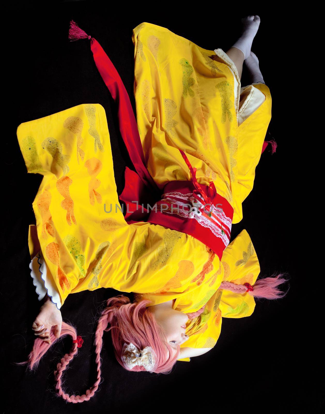 Portrait of young girl lay in yellow kimono cosplay costume
