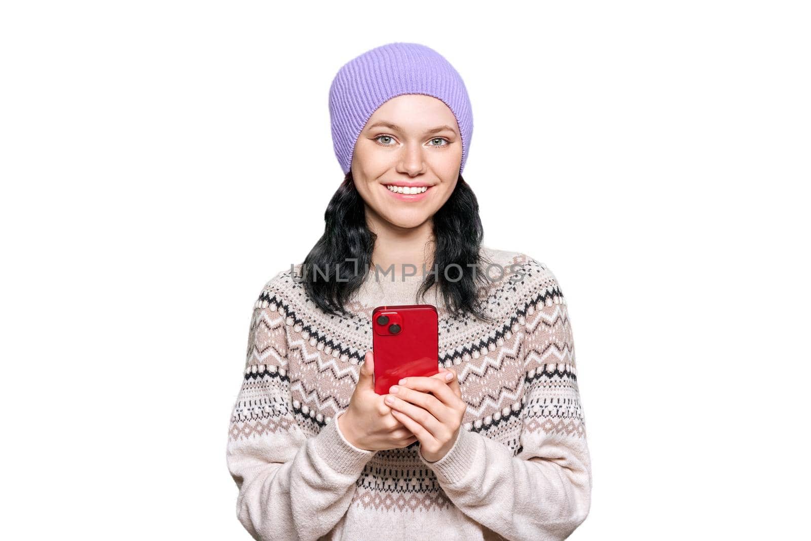 Beautiful teenage girl in hat in sweater with smartphone on white isolated background by VH-studio