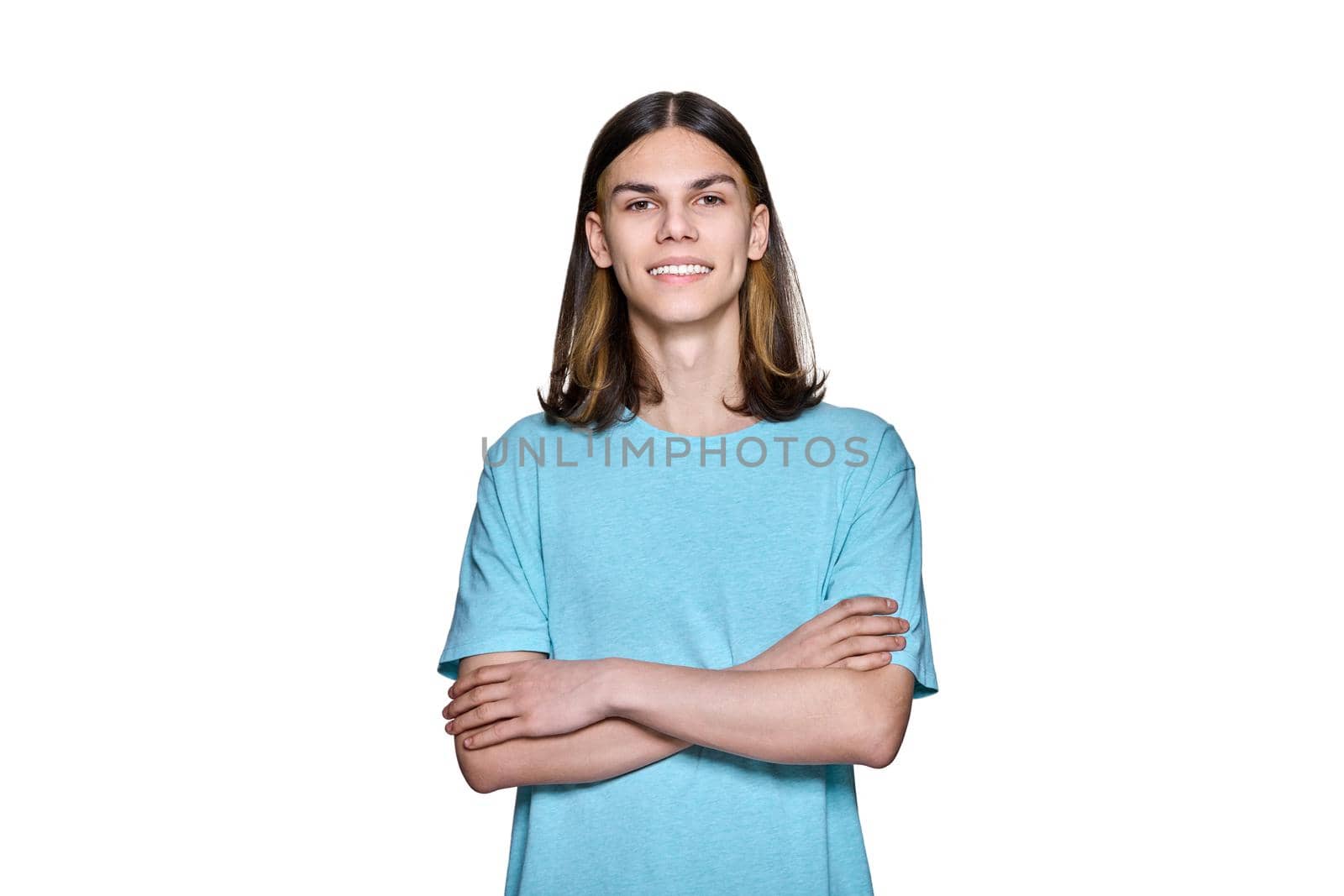 Portrait of smiling teenage guy looking at camera on white isolated background by VH-studio