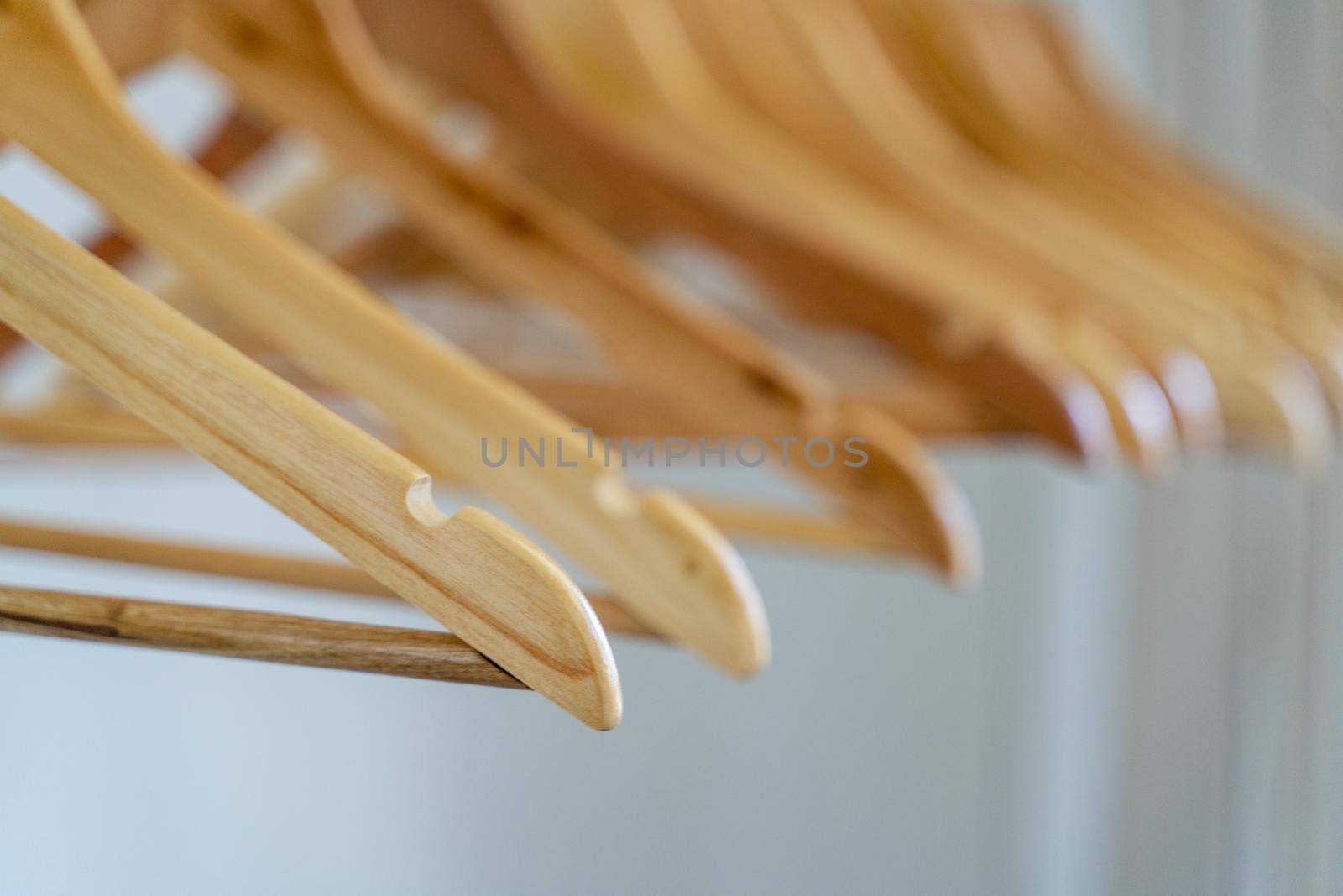 Close-up of wardrobe with wooden clothes hanger, by Matiunina