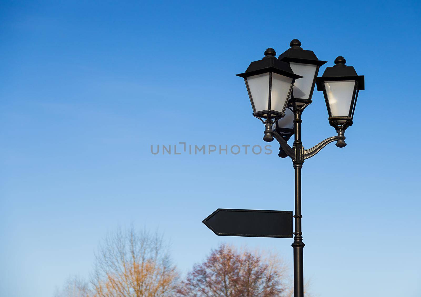 Big, old, black lantern with a pointer against the blue sky, copy paste by Ramanouskaya