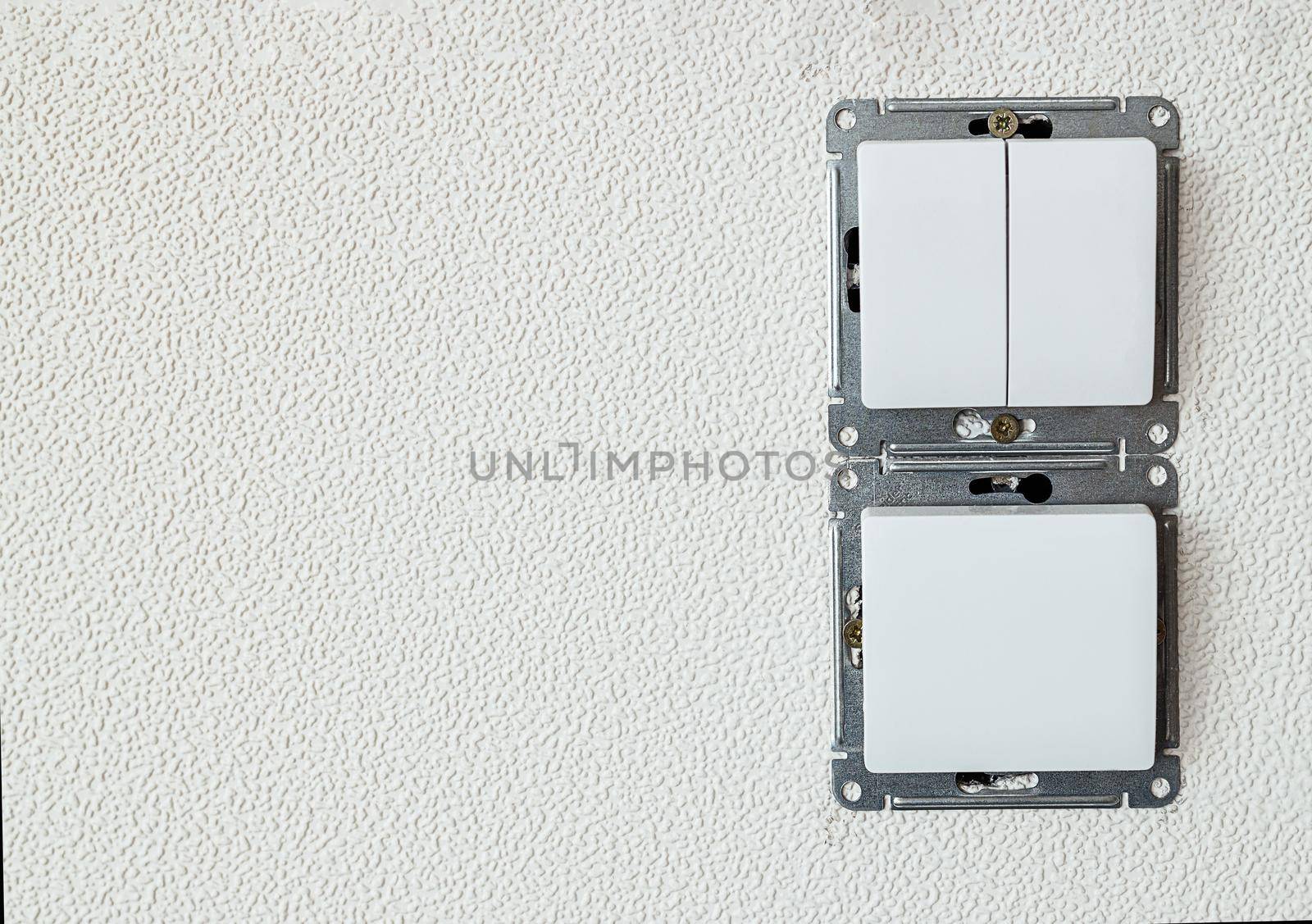 installation of an electric switch for light, on a background of a white wall with copy paste. The concept of repair and installation of electricians in new apartments. Large palan socket without frame