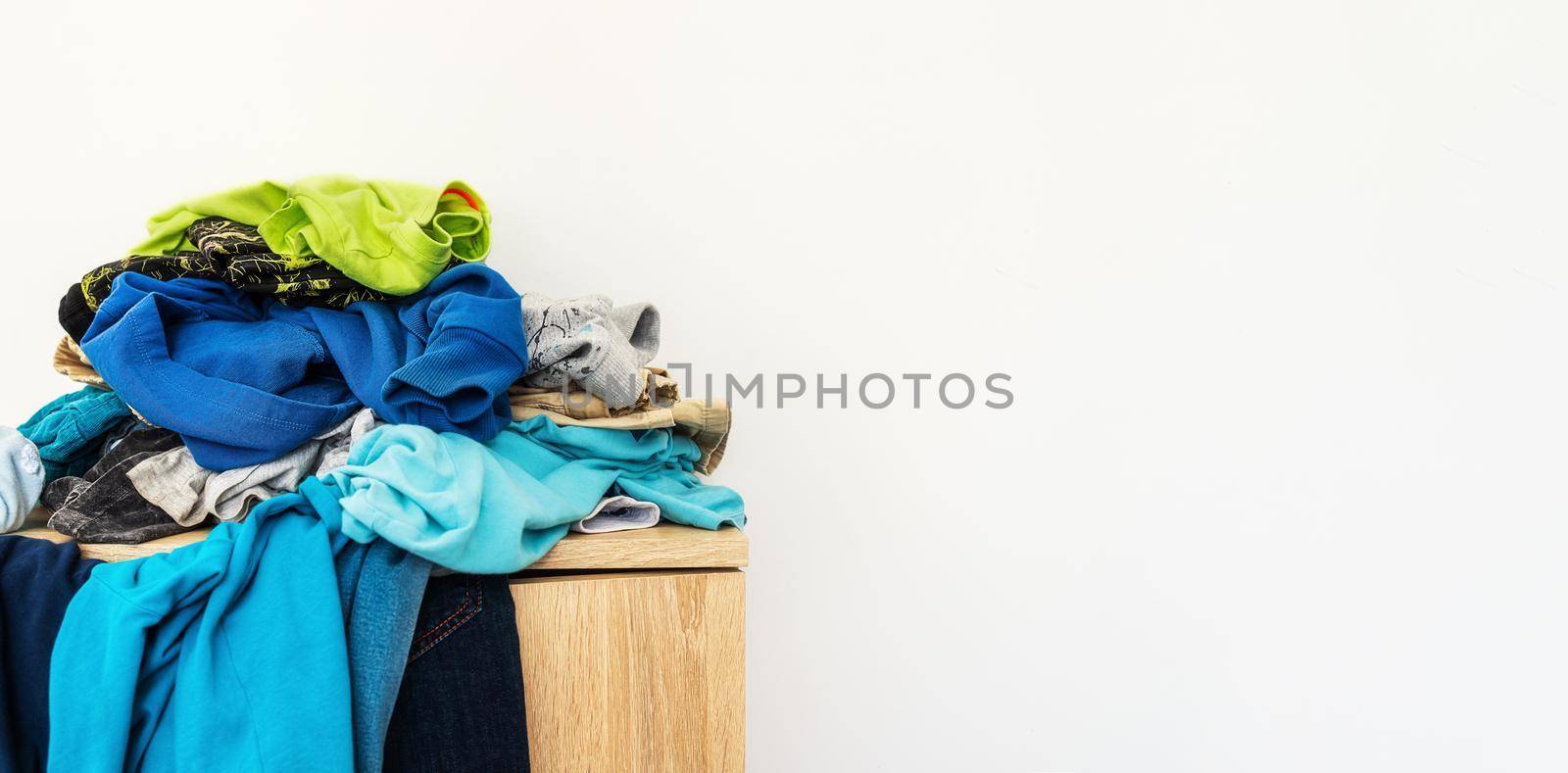 Banner with copy paste for space organization specialist and ordering concept. A pile of scattered blue things in pile on shelf. close-up, empty space for your design. Mockup cleaning product, laundry