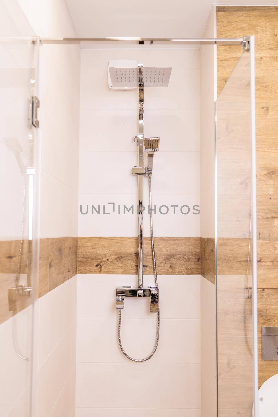 modern bright shower cabin close-up, with water equipment, vertical, wooden background by Ramanouskaya
