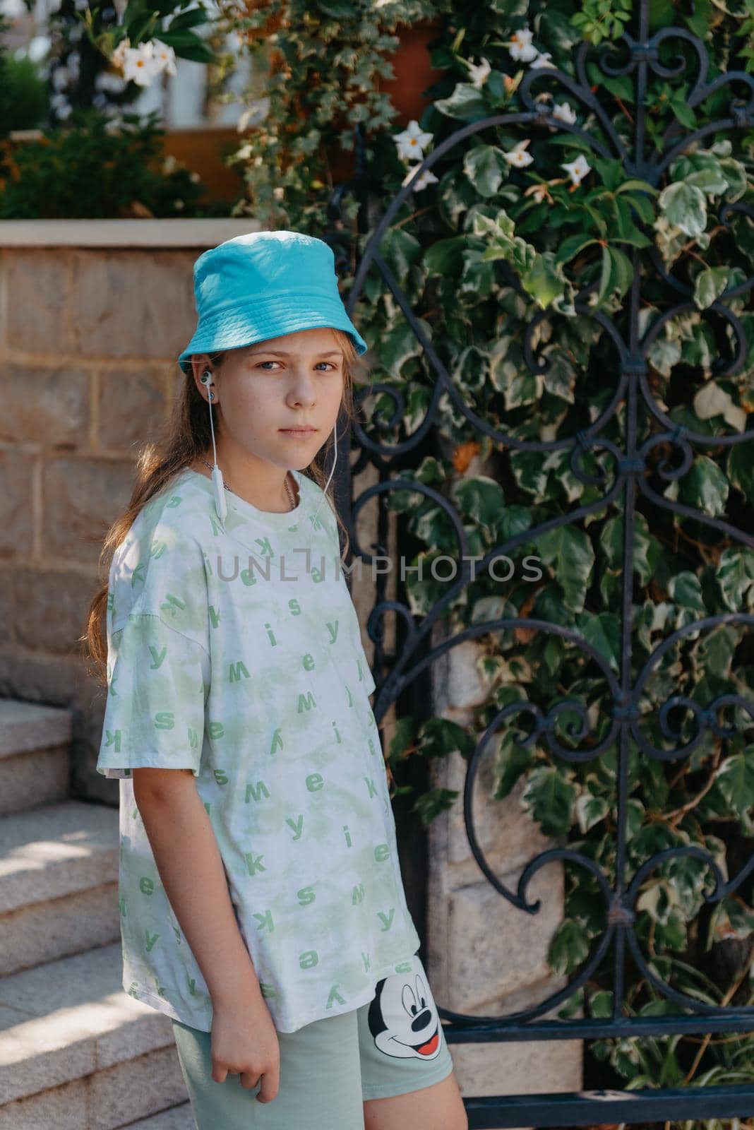 Girl standing in the entrance to the back yard. A beautiful cozy courtyard, a girl stands near the entrance to a beautiful courtyard by Andrii_Ko