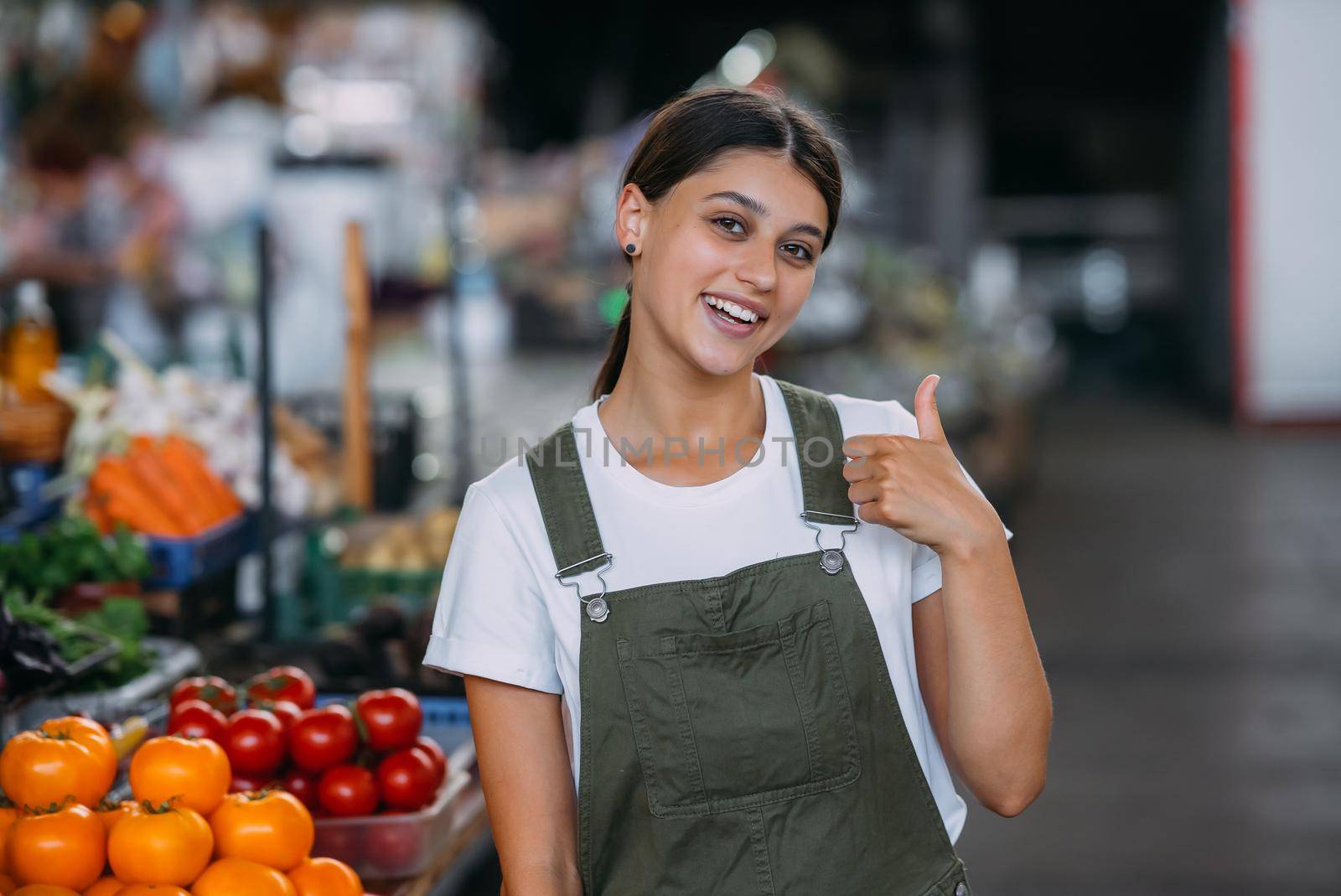 Woman seller at the counter with vegetables.