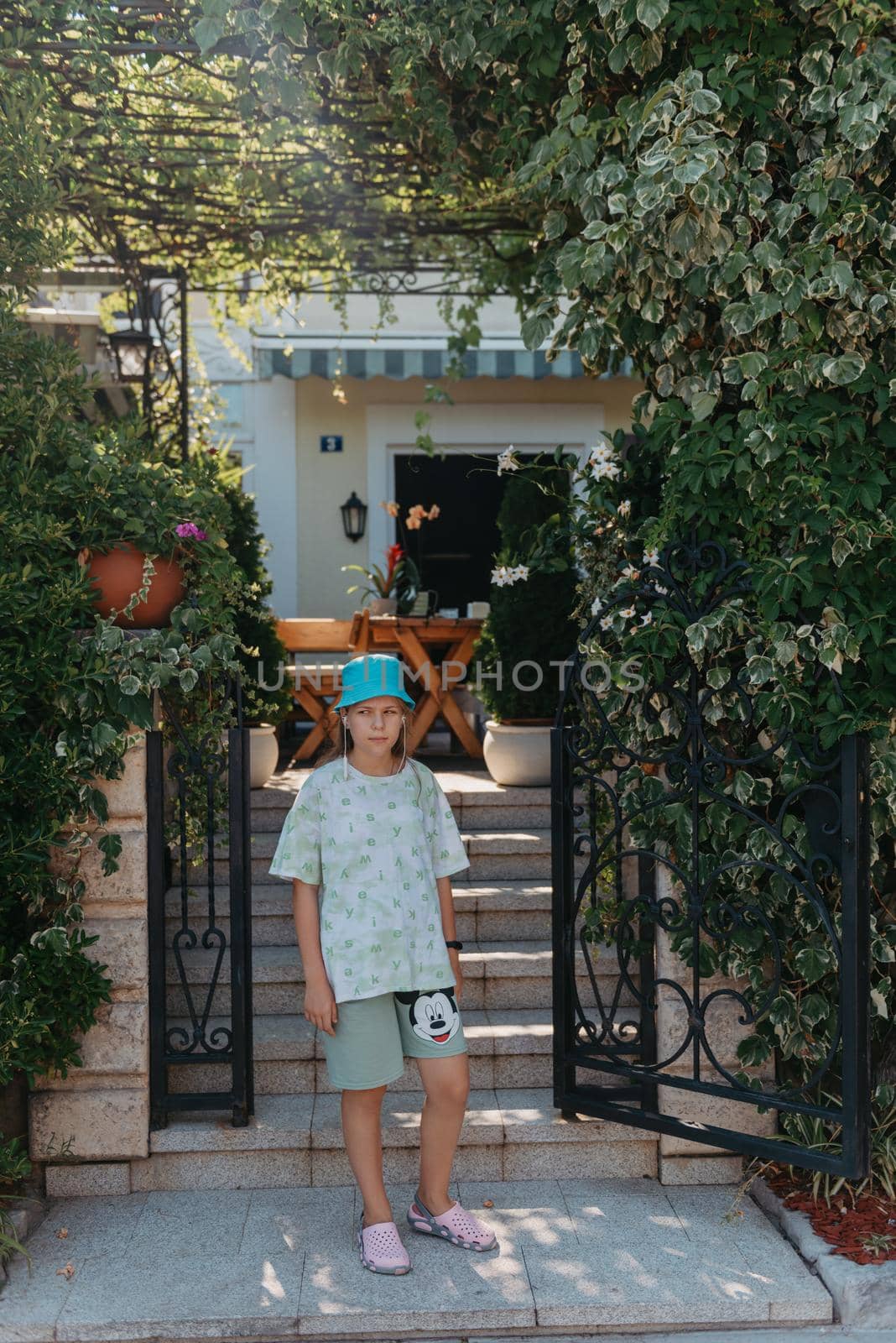 Girl standing in the entrance to the back yard. A beautiful cozy courtyard, a girl stands near the entrance to a beautiful courtyard by Andrii_Ko