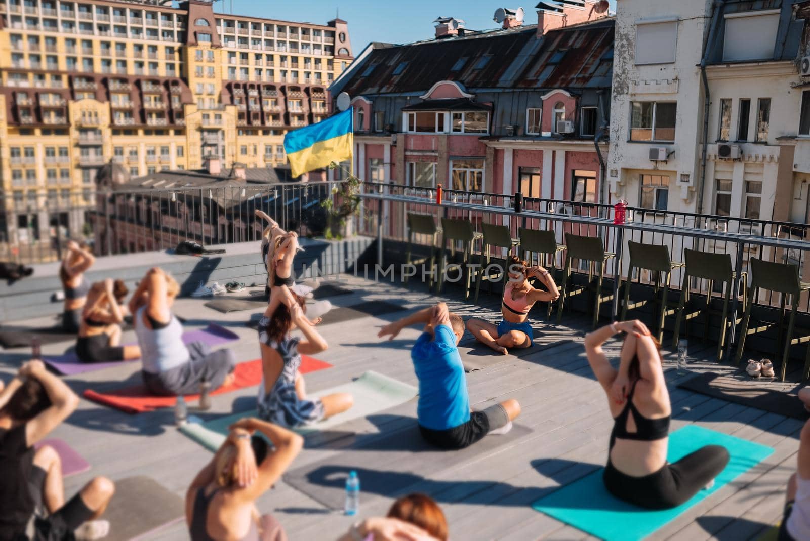 Group of peoples practice yoga outdoors on the roof of the building. Outdoor group yoga classes. Meditation and wellness lifestyle concept