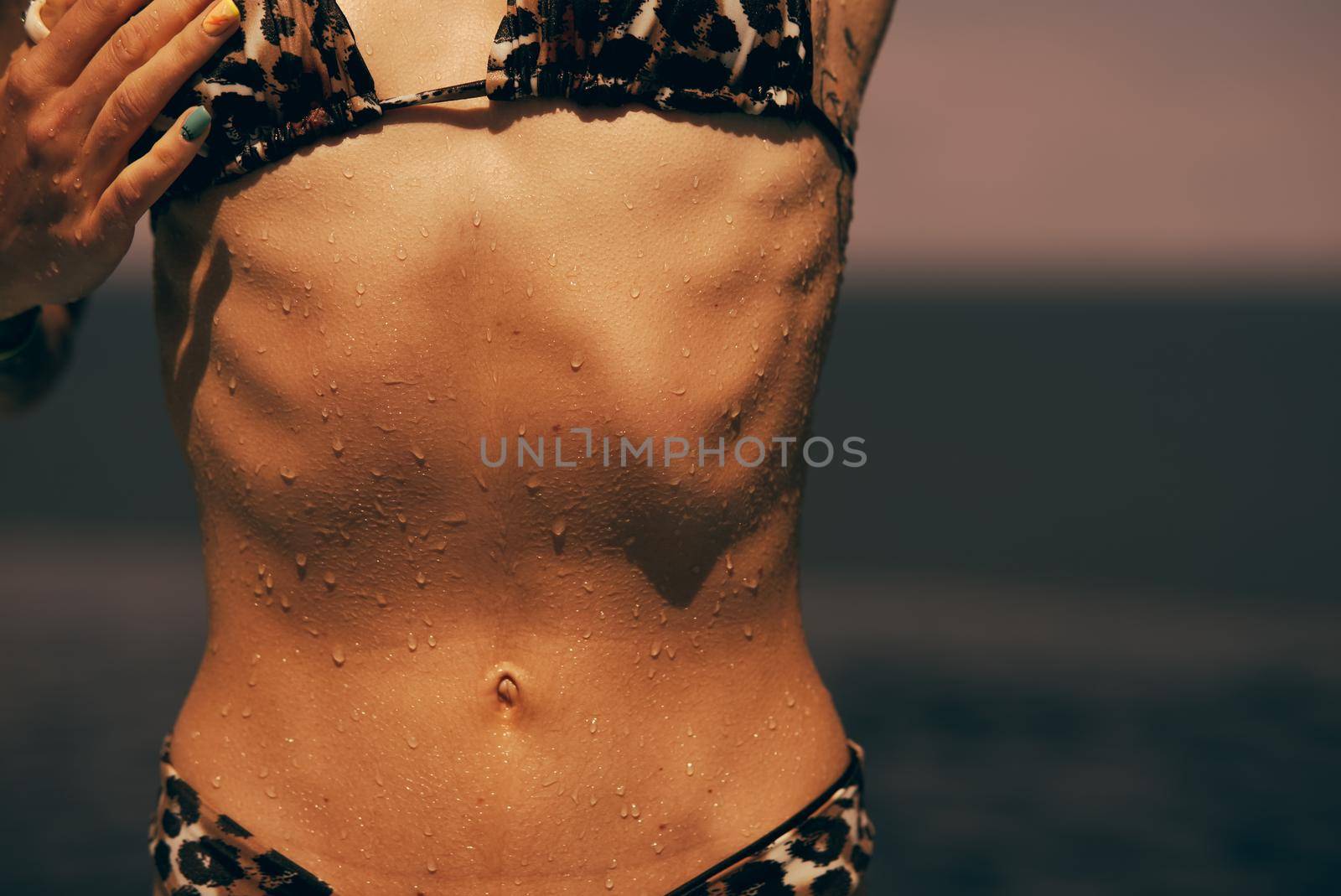 Torso of slim attractive female with flat belly in white underwear. Close up shot of unrecognizable fit woman