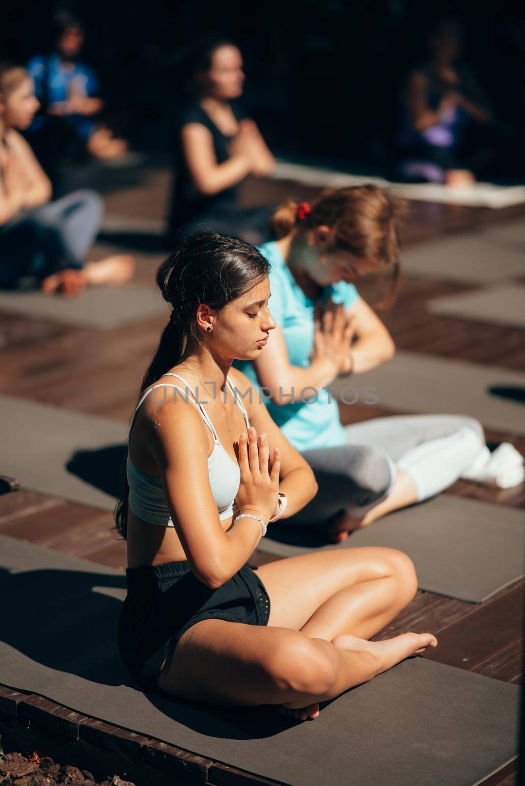 A woman does yoga together with her group in the open air. Healthy lifestyle concept