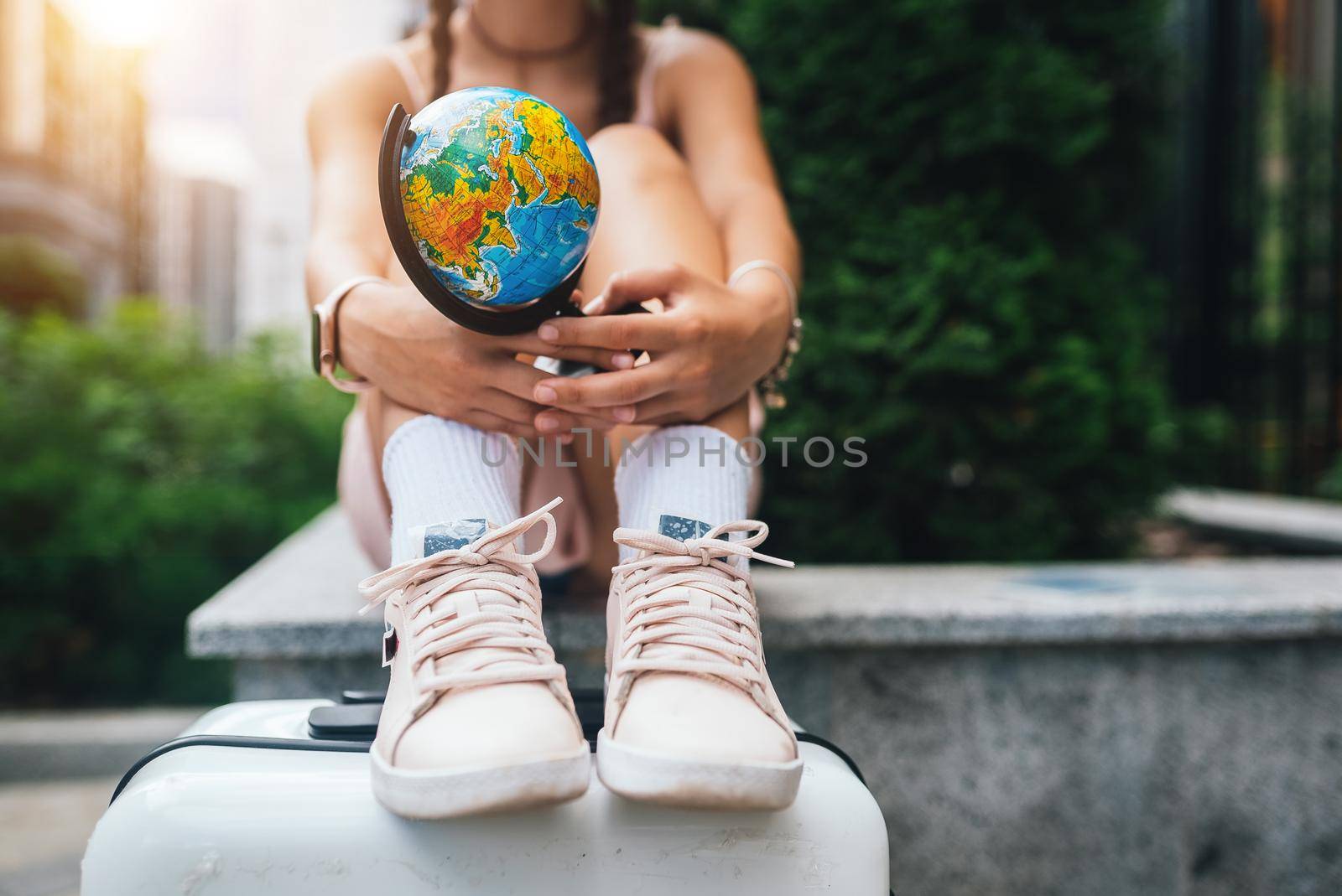 A beautiful young woman holds a small globe in her hands. Lifestyle and travel Concept
