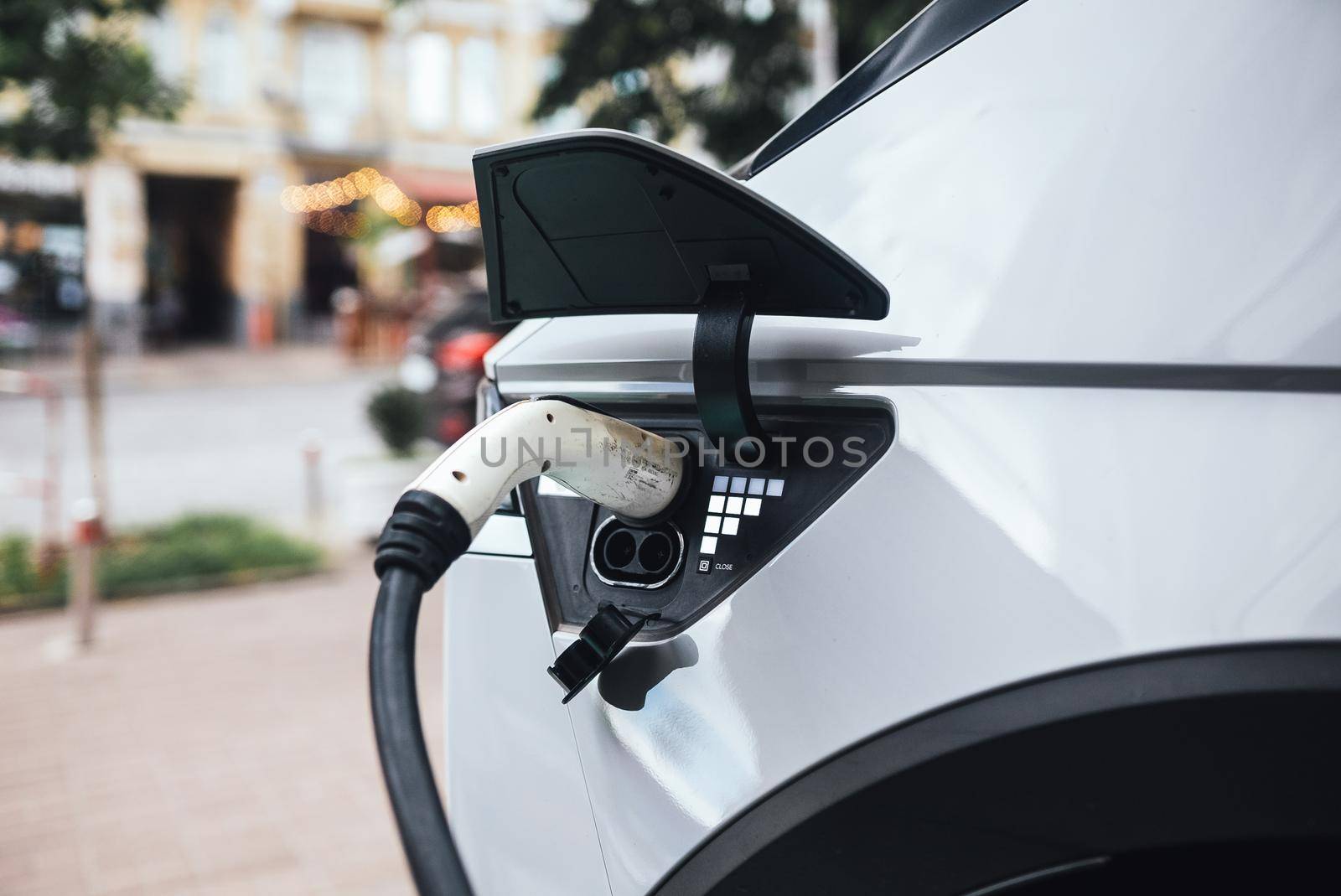 Close up of the power supply plugged into an electric car being charged.