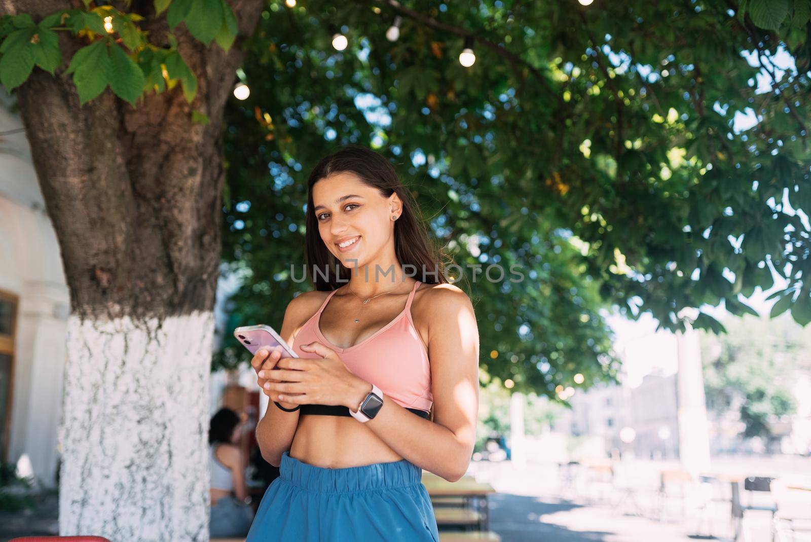 Photo of charming pretty young lady communicating modern gadget smiling outside urban city street