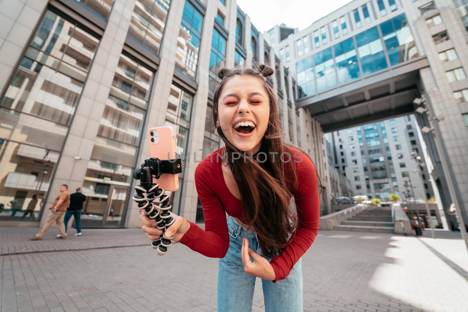 Young female blogger streaming on the street. Close view