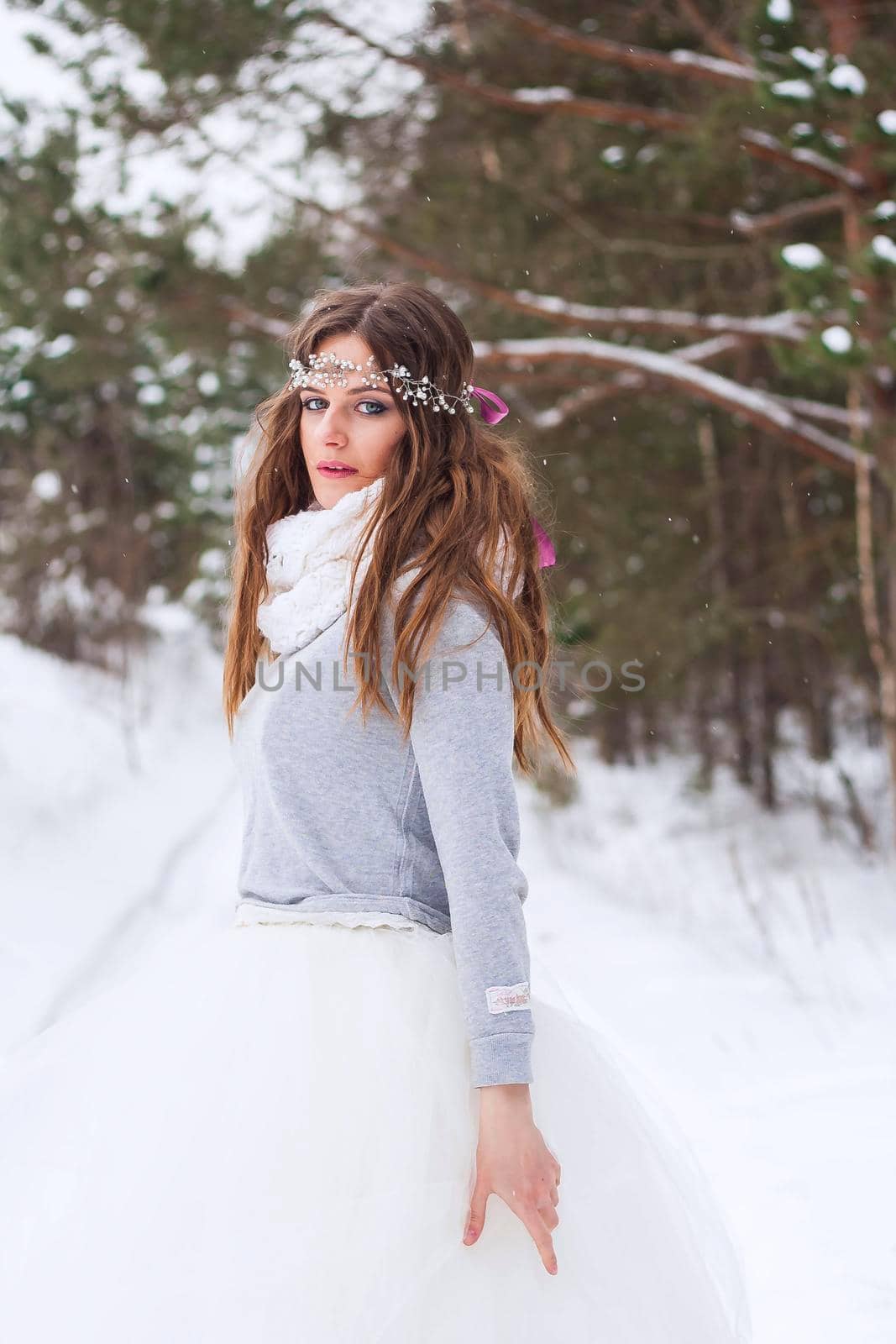 Beautiful bride in a white dress with a bouquet in a snow-covered winter forest. Portrait of the bride in nature.Beautiful bride in a white dress with a bouquet in a snow-covered winter forest. Portrait of the bride in nature.