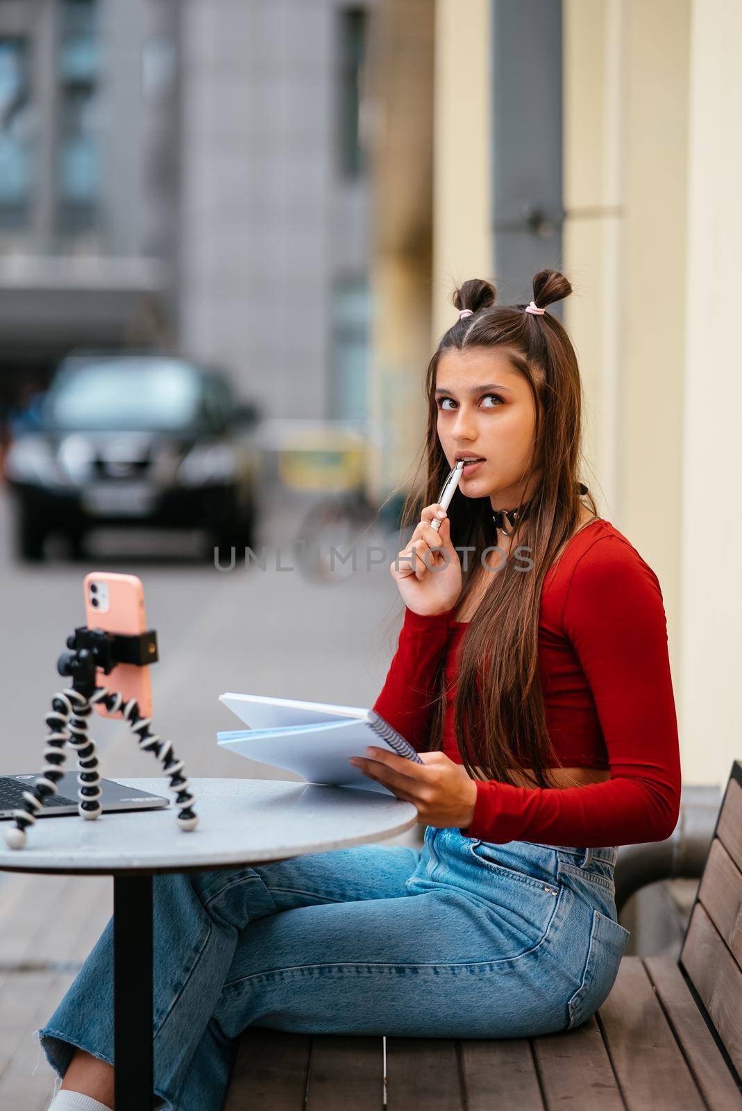 Young woman in a summer cafe doing remote work. Freelancer woman. Small business