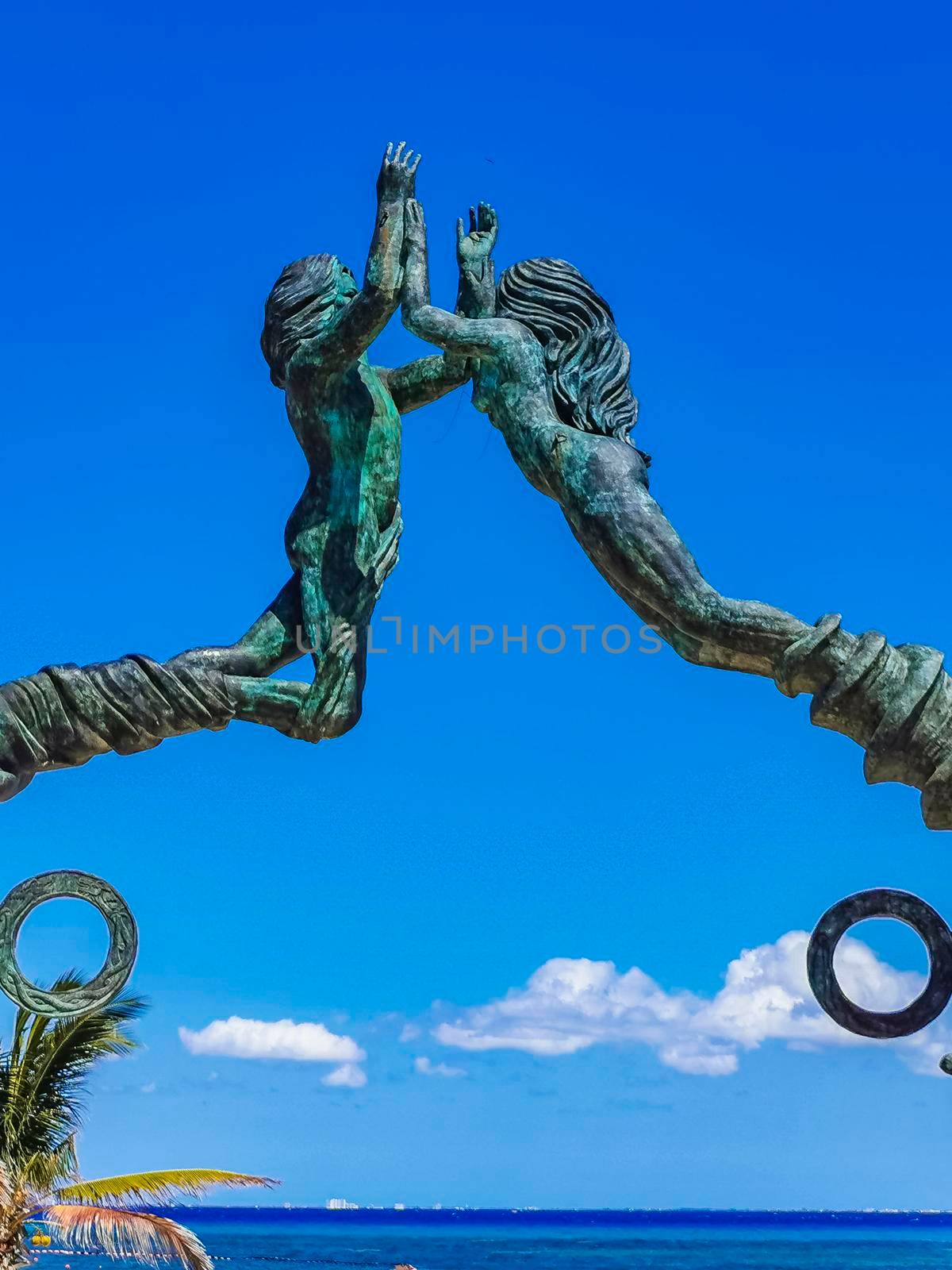 The ancient architecture of the Portal Maya in the Fundadores park with blue sky and turquoise seascape and beach panorama in Playa del Carmen Quintana Roo Mexico.