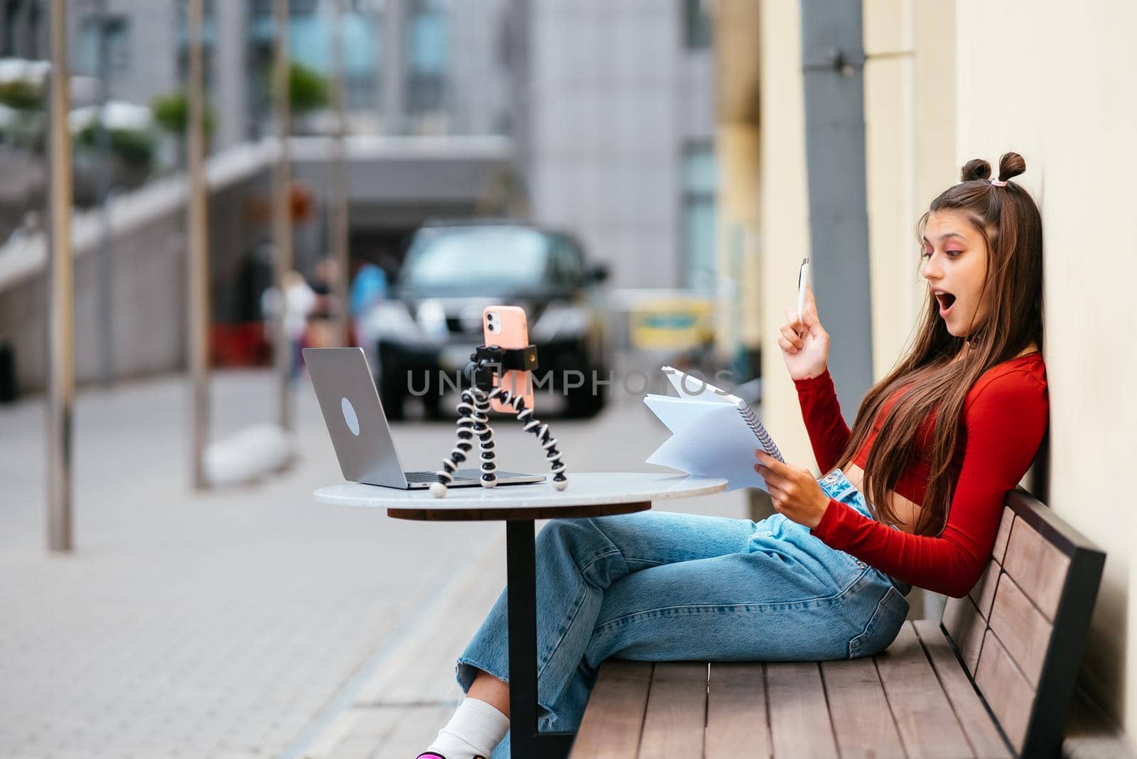 Young woman in a summer cafe doing remote work. Freelancer woman. Small business