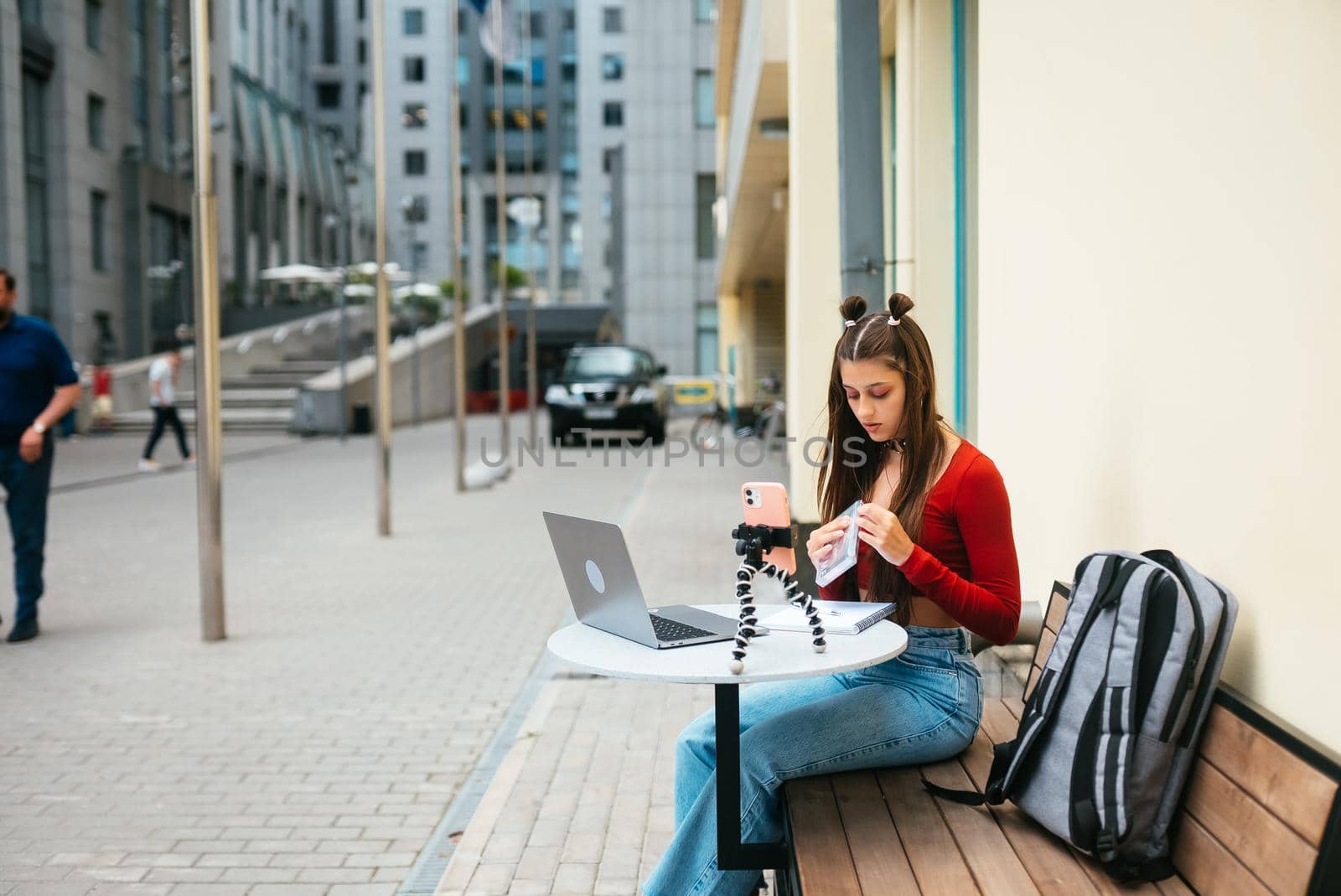 Young woman in a summer cafe doing remote work. Freelancer woman. Small business