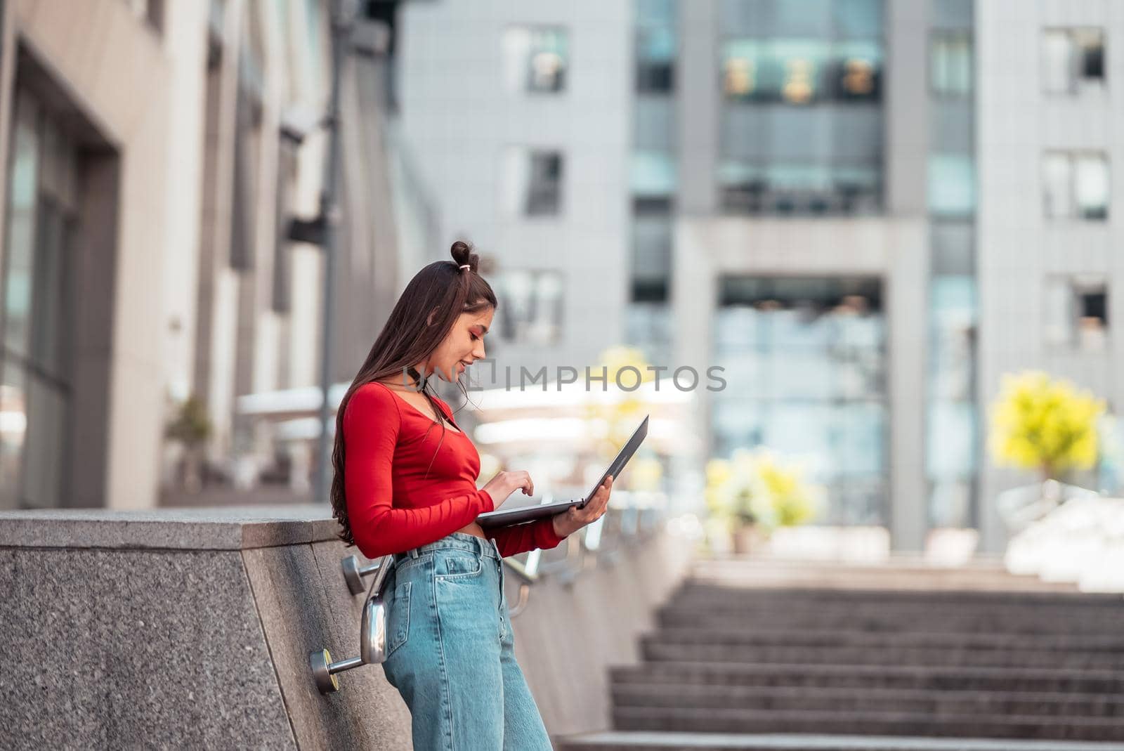 Beautiful young woman on the street and working using computer laptop