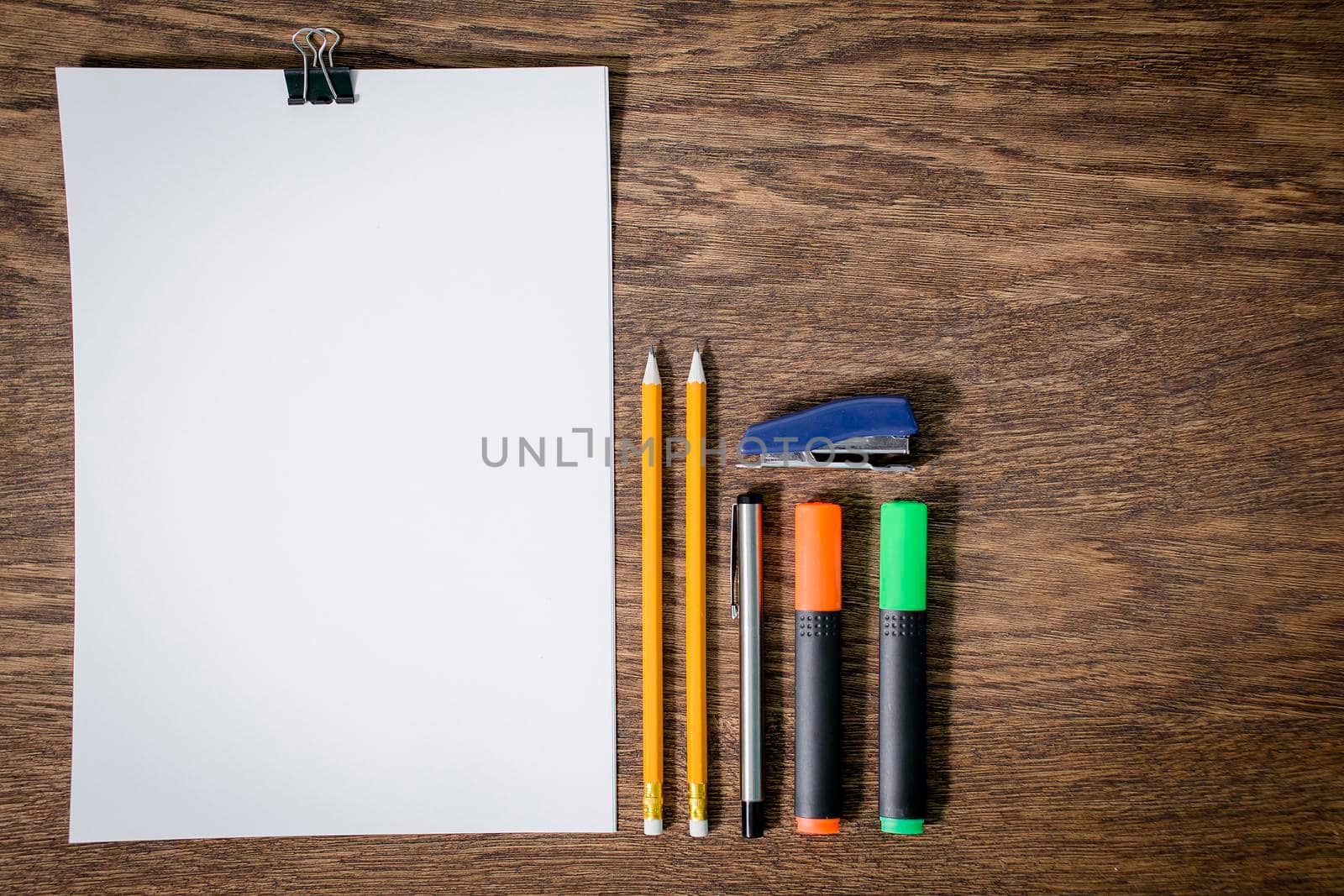 Paper and pencils on the wooden table. close-up.